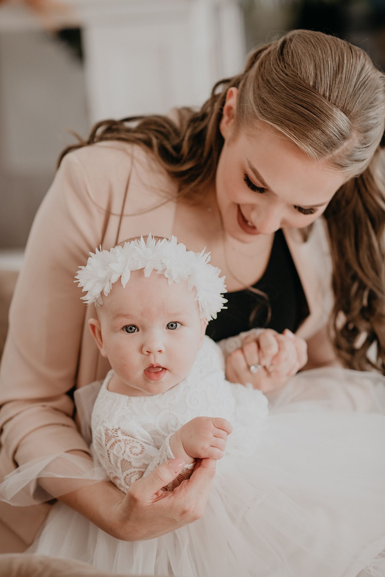A series of intimate indoor portraits showing tender moments between parent and baby in soft, neutral tones.