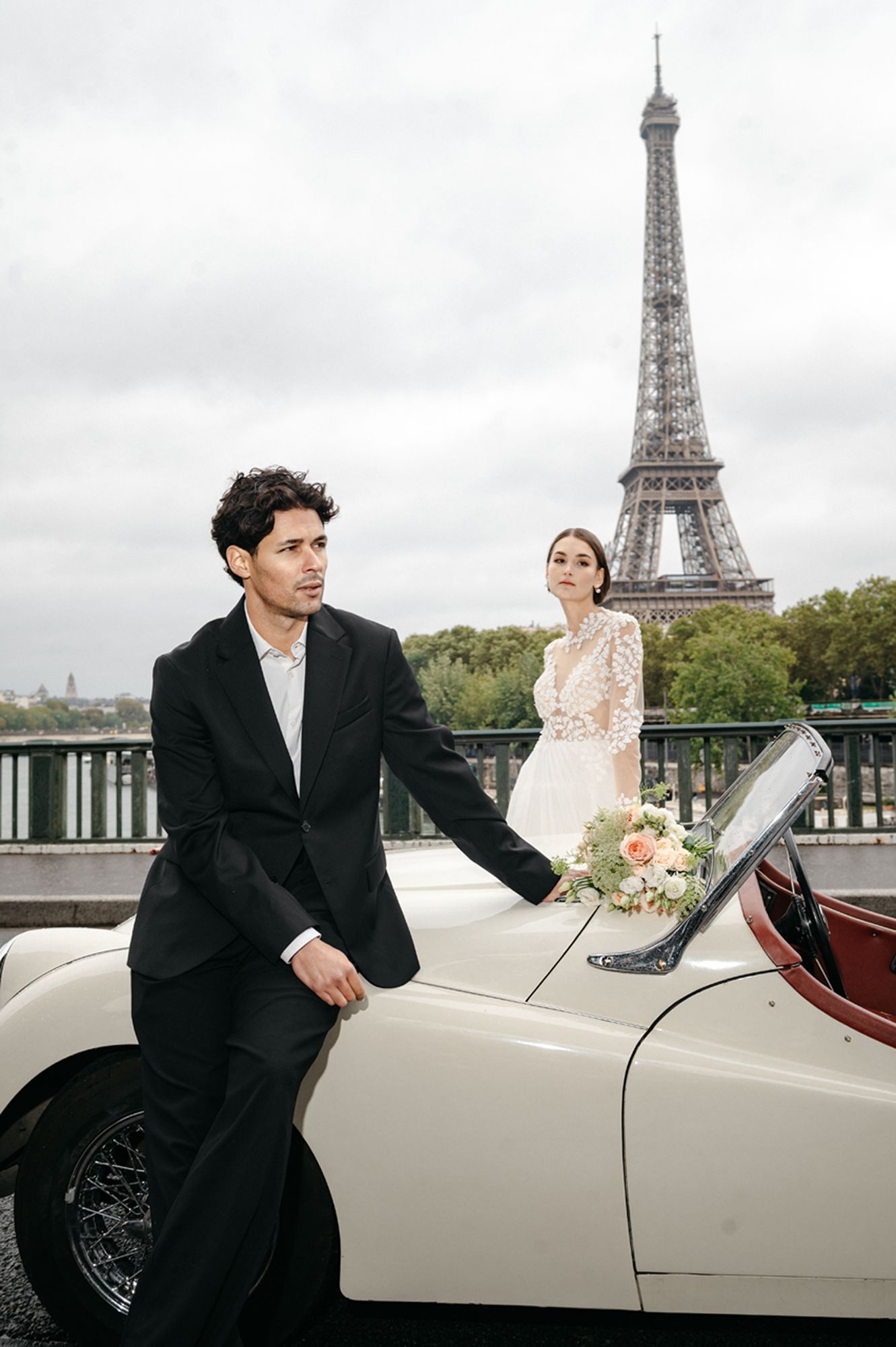 A romantic wedding photoshoot with a vintage white car and the iconic Eiffel Tower in the background in Paris.