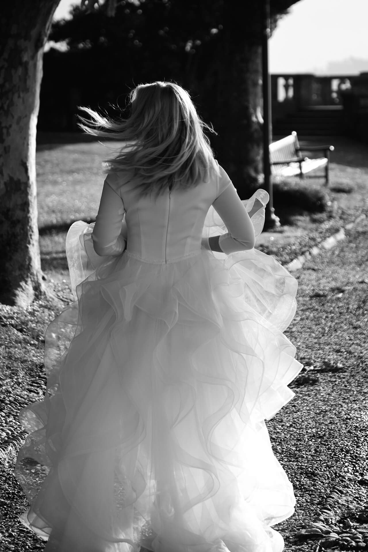 Black and white photos showing the flowing layers of a white wedding dress in motion.