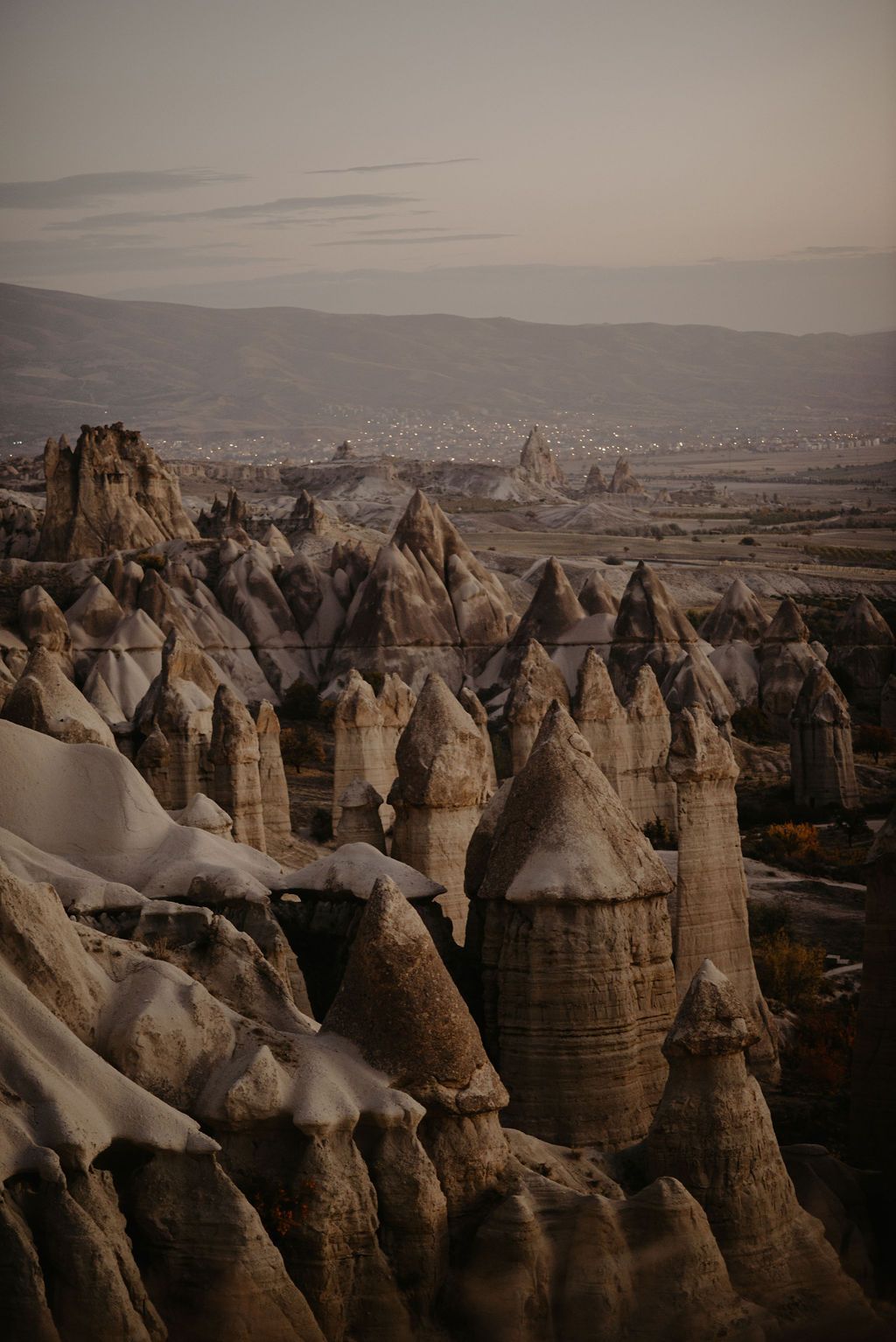 Aerial view of Cappadocia fairy chimneys rock formations at dusk in Turkey.
