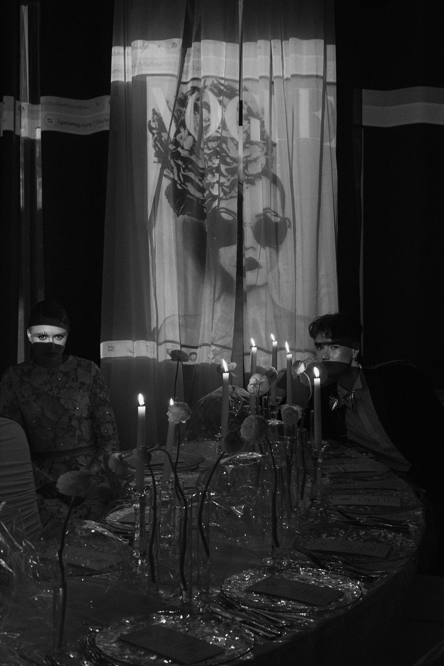 Four black and white photos showing lit candles in a dark room with curtained windows creating a moody atmosphere.