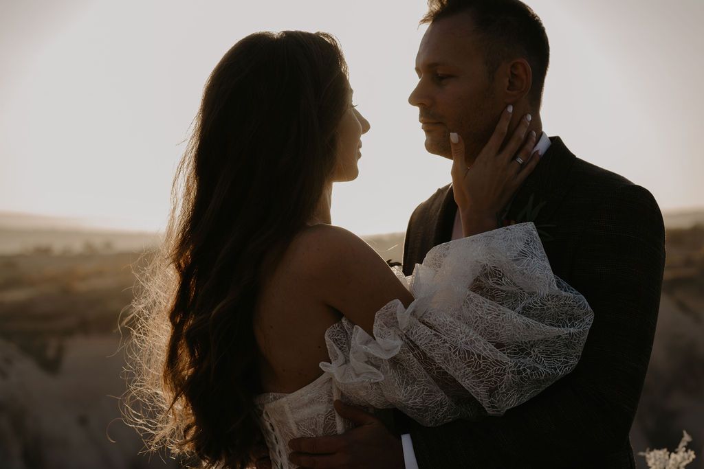 Couple sharing romantic moment at sunset during desert elopement photography session.