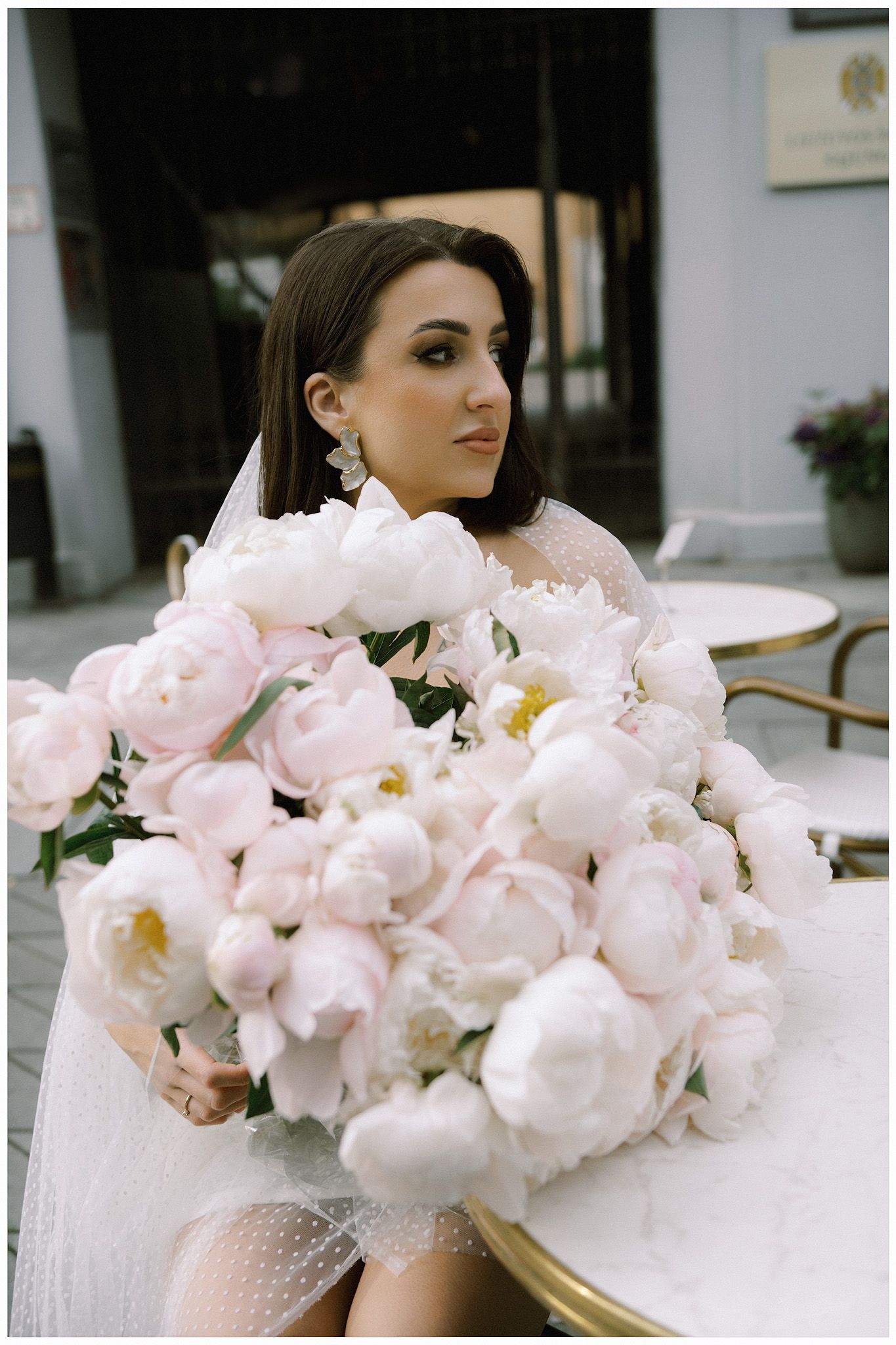 A dreamy sequence of soft pink peonies transitioning to a person holding a romantic floral bouquet.