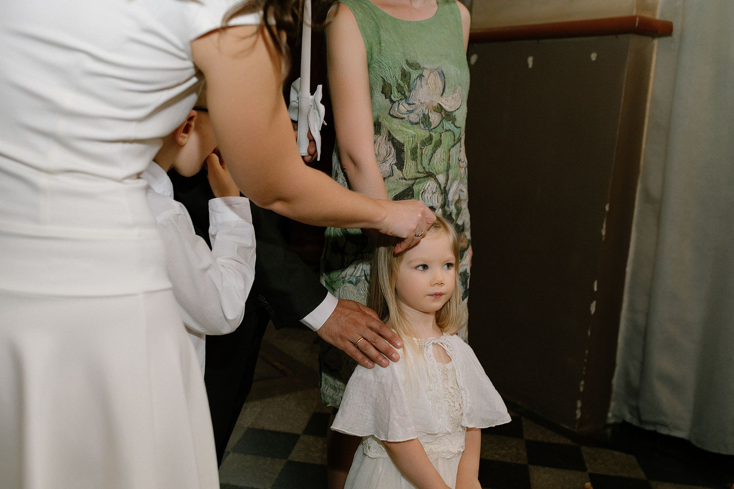 Medical professional in white coat performs examination on young patient while parent provides comfort and support.
