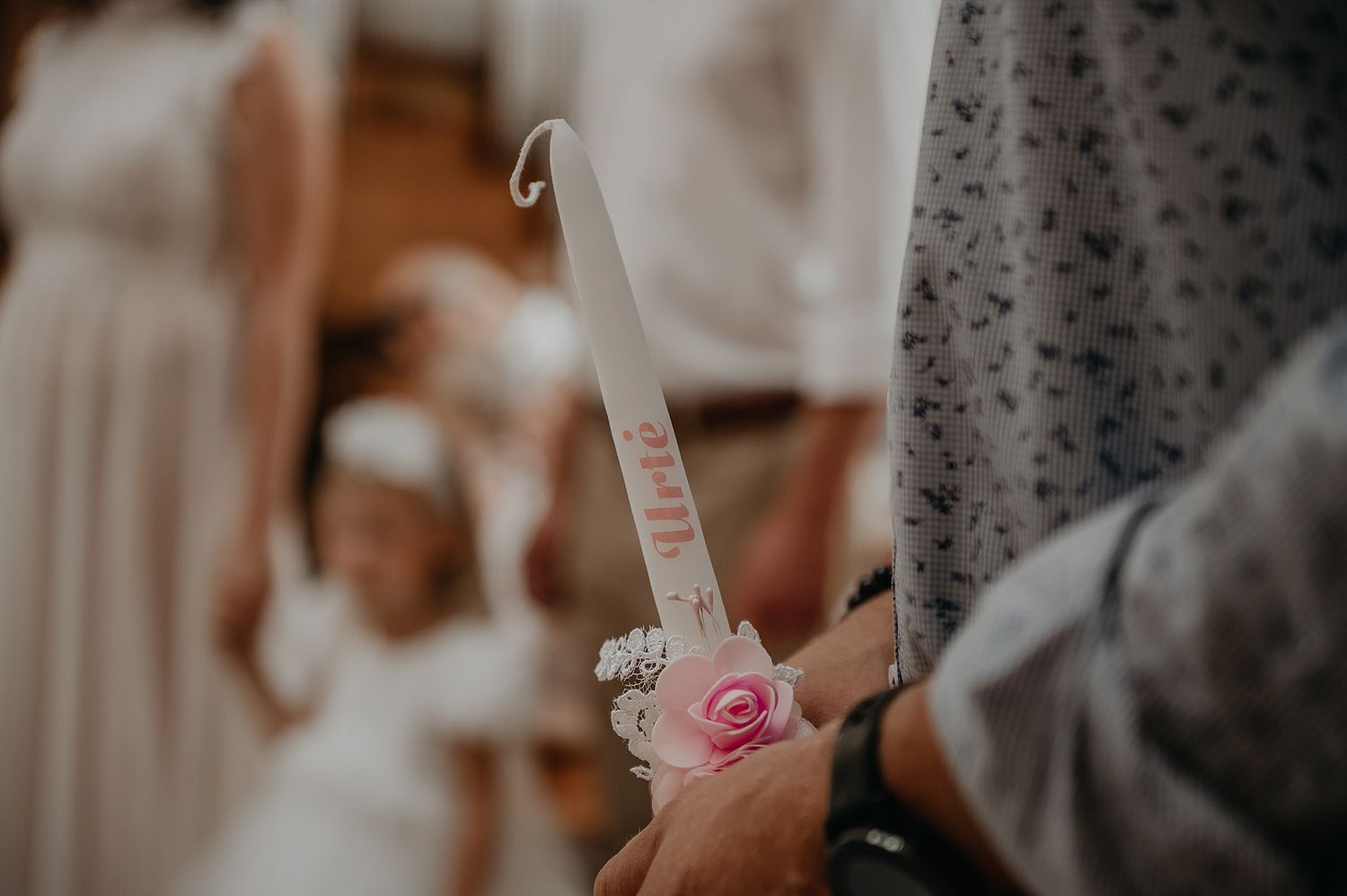 A delicate pink rose and champagne flute are held during an elegant wedding celebration.