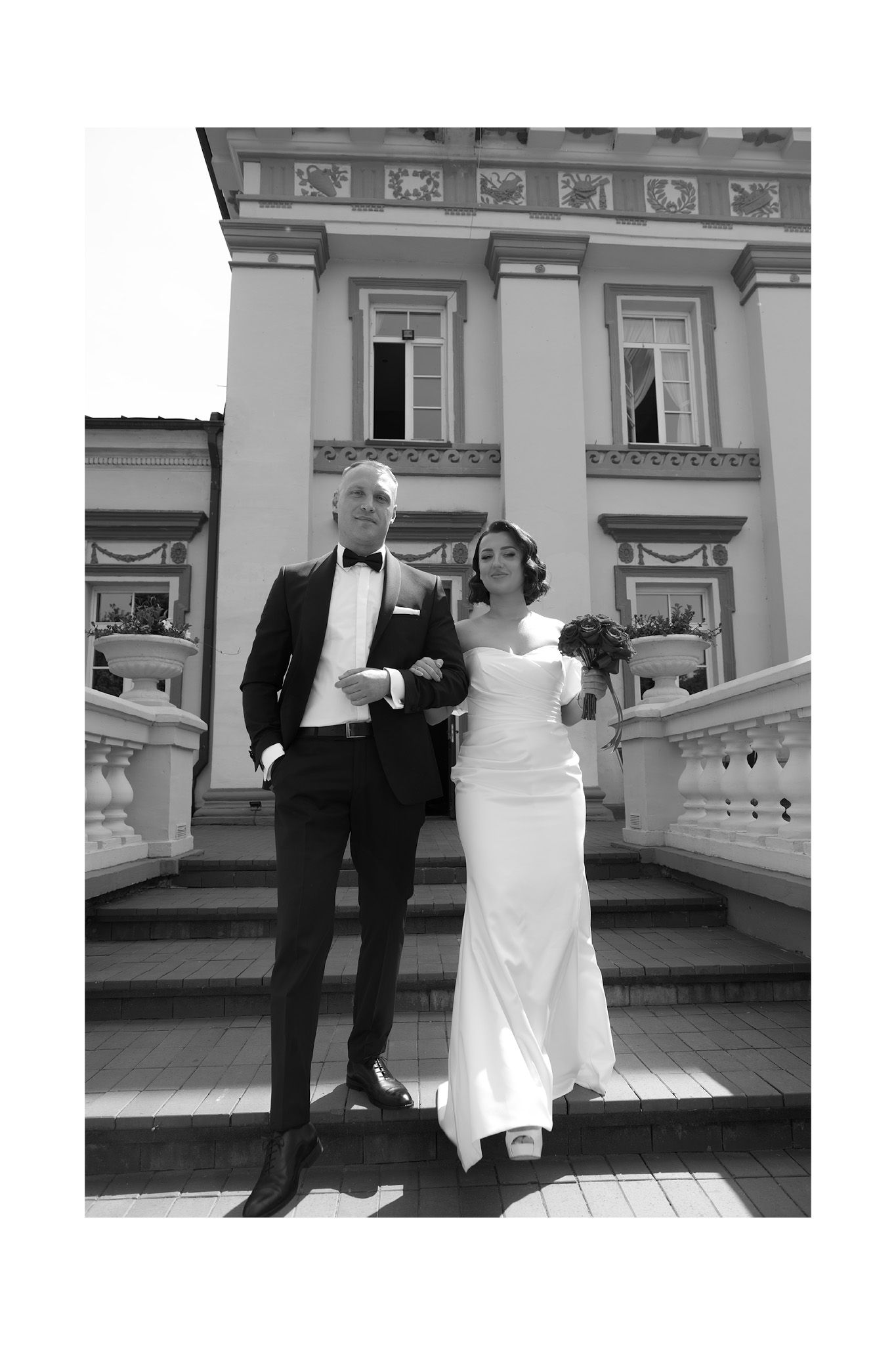 Black and white wedding photo series showing a couple in formal attire posing on an elegant porch with white columns.