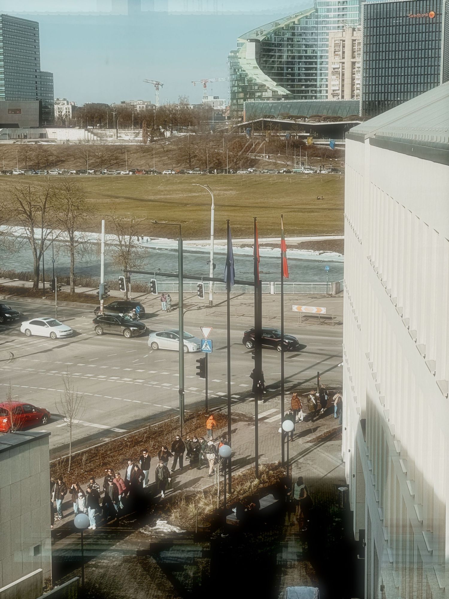 Aerial view of urban parking lot and buildings with curved architecture in winter landscape.