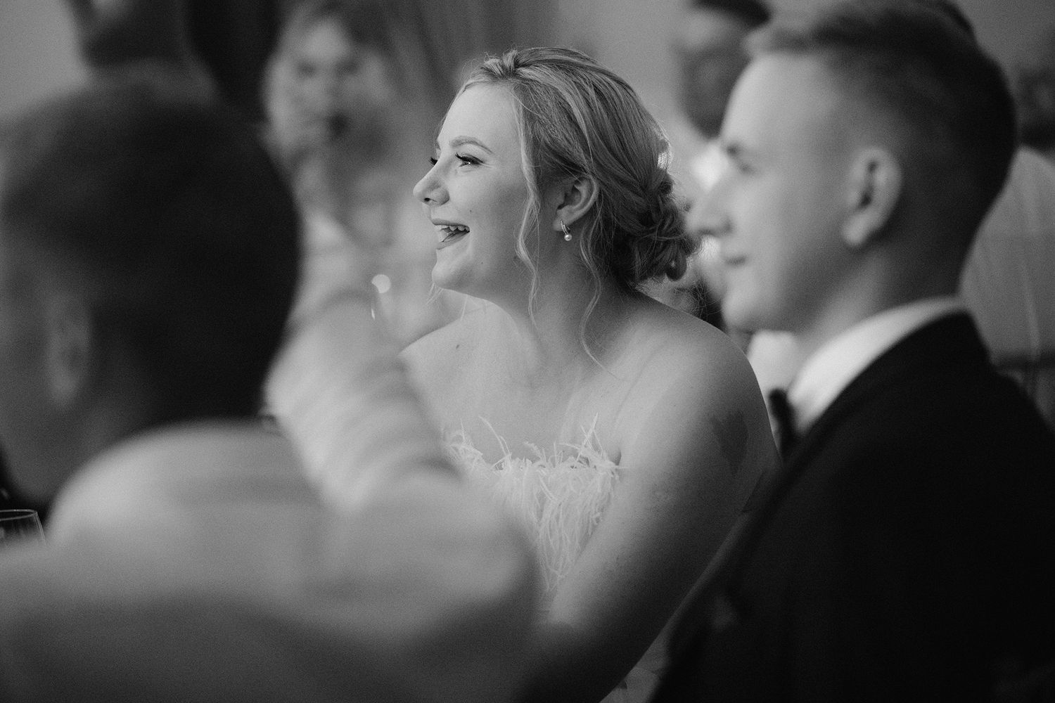 A joyful black and white wedding reception scene shows people laughing and celebrating together.