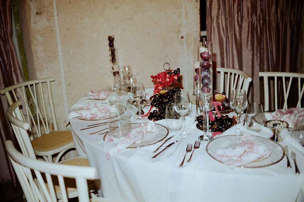 Elegant white tablecloth dining table set with crystal glasses, silverware, and floral centerpiece for a formal event.