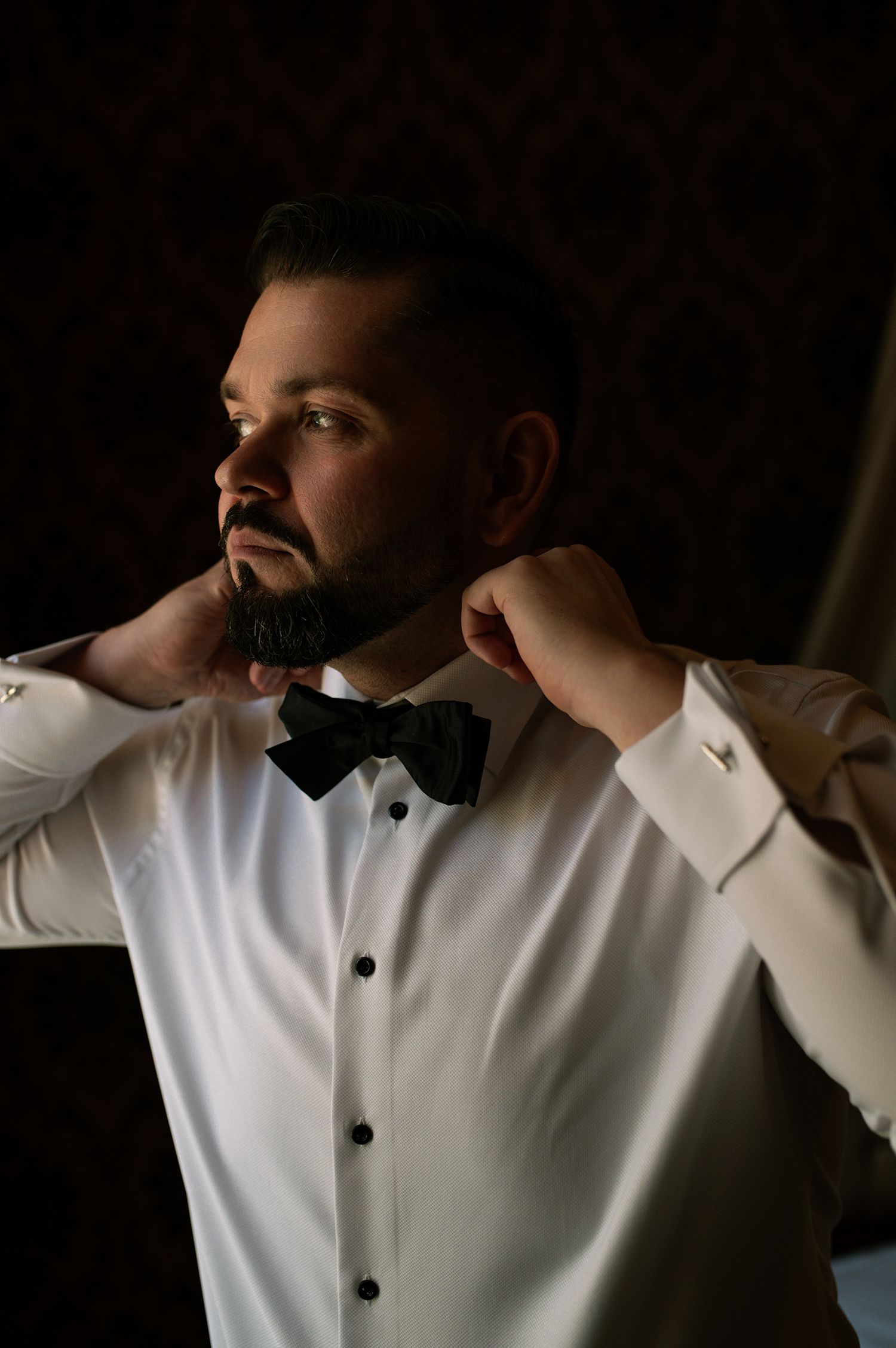 A sequence of moody portraits showing someone in a white dress shirt against a dark background in dramatic lighting.