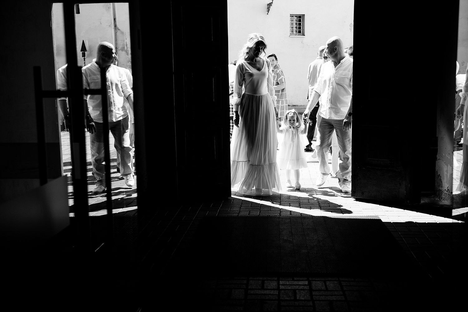 A series of black and white silhouettes in doorways showing dramatic lighting and architectural framing.