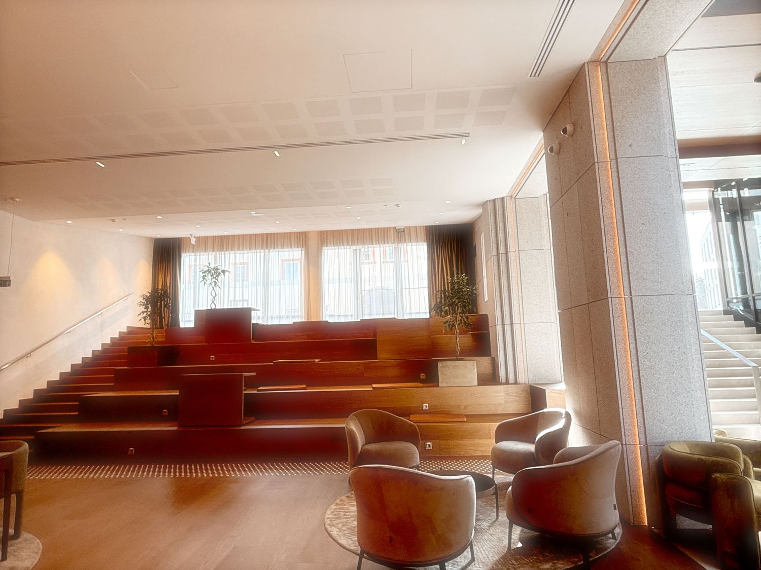 Modern interior staircase with red carpeting and white walls in an office building or commercial space.