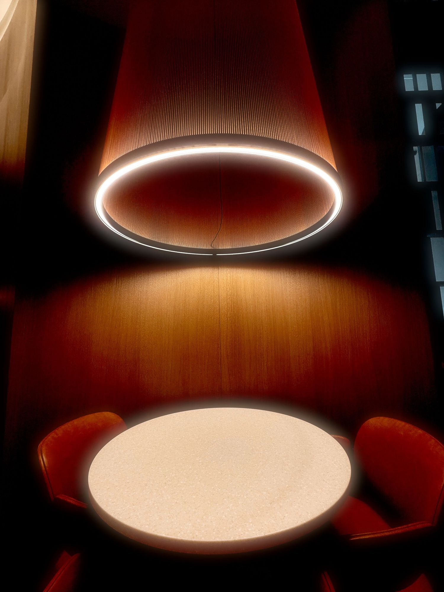A sequence of circular pendant lights casting warm glows on wooden surfaces creates a dramatic lighting progression.