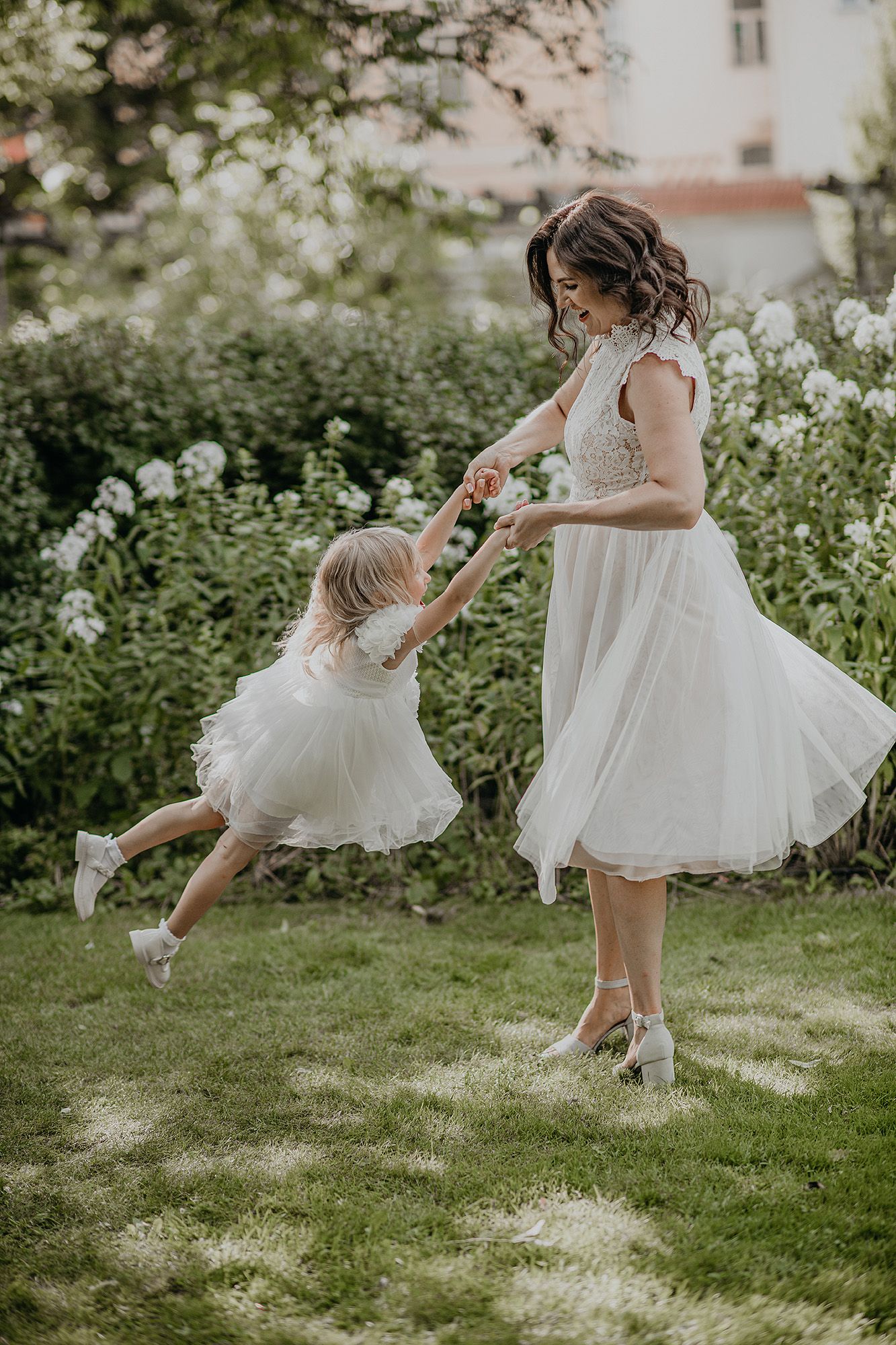 A person in a white dress spins playfully on a grassy lawn in a series of connected motion photographs.
