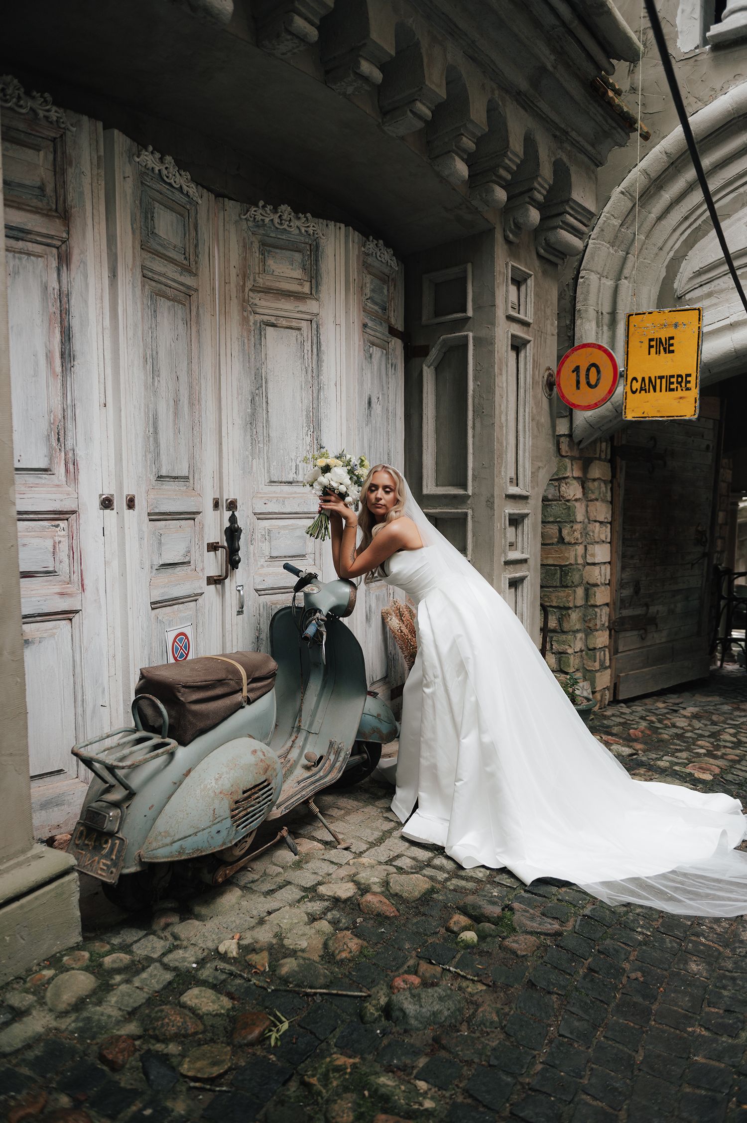 A romantic wedding photo series showing a bride in a flowing white dress against an old stone alleyway.