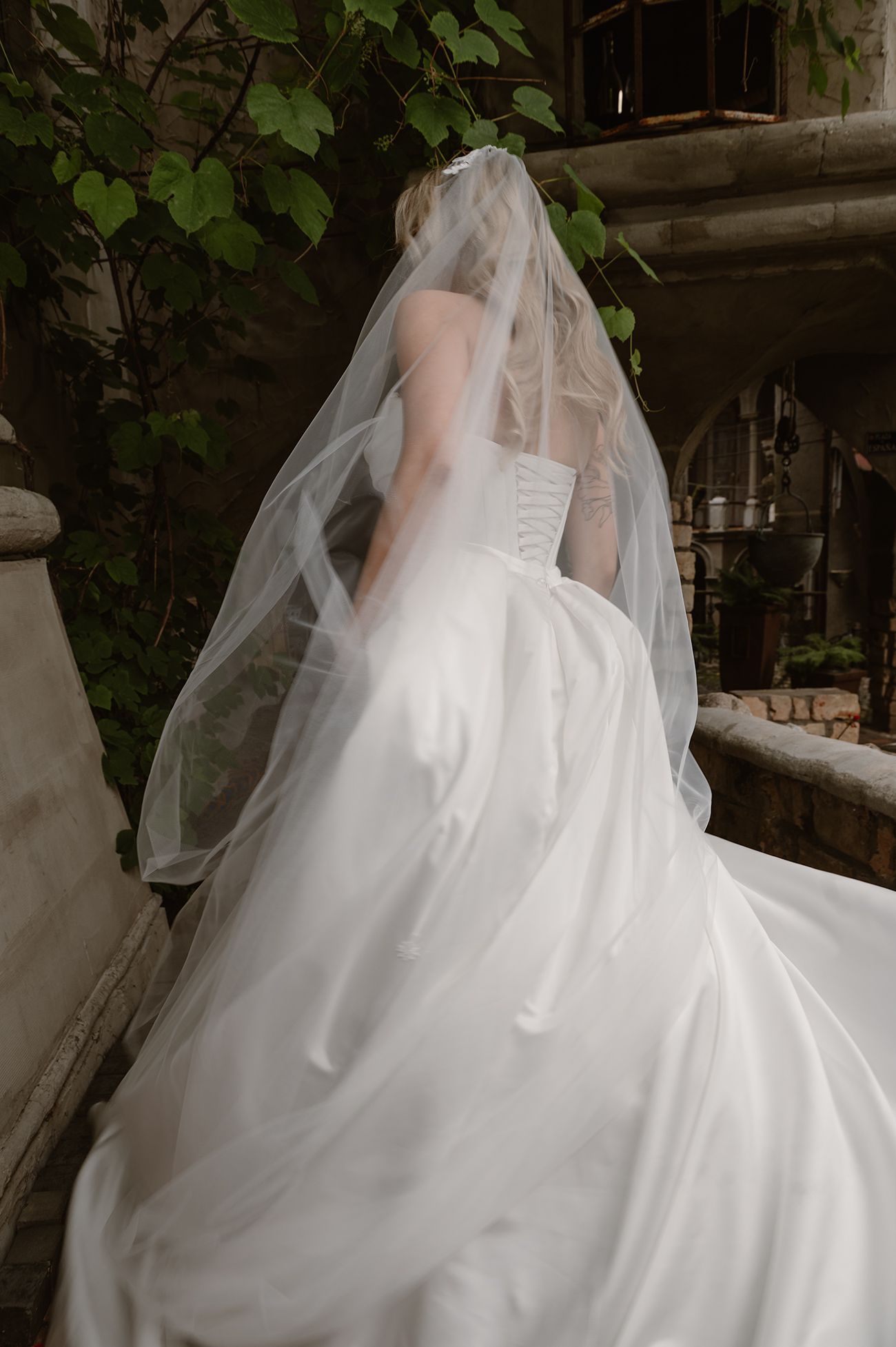 A flowing white wedding dress with a dramatic tulle veil captured in motion across multiple artistic frames.