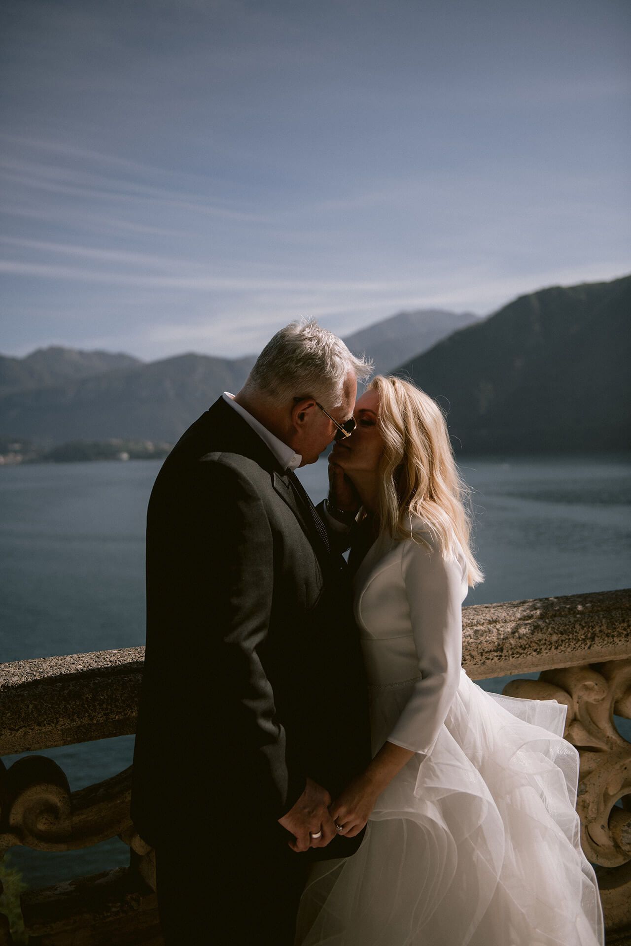 A romantic wedding photoshoot sequence against a scenic mountain lake backdrop at sunset.