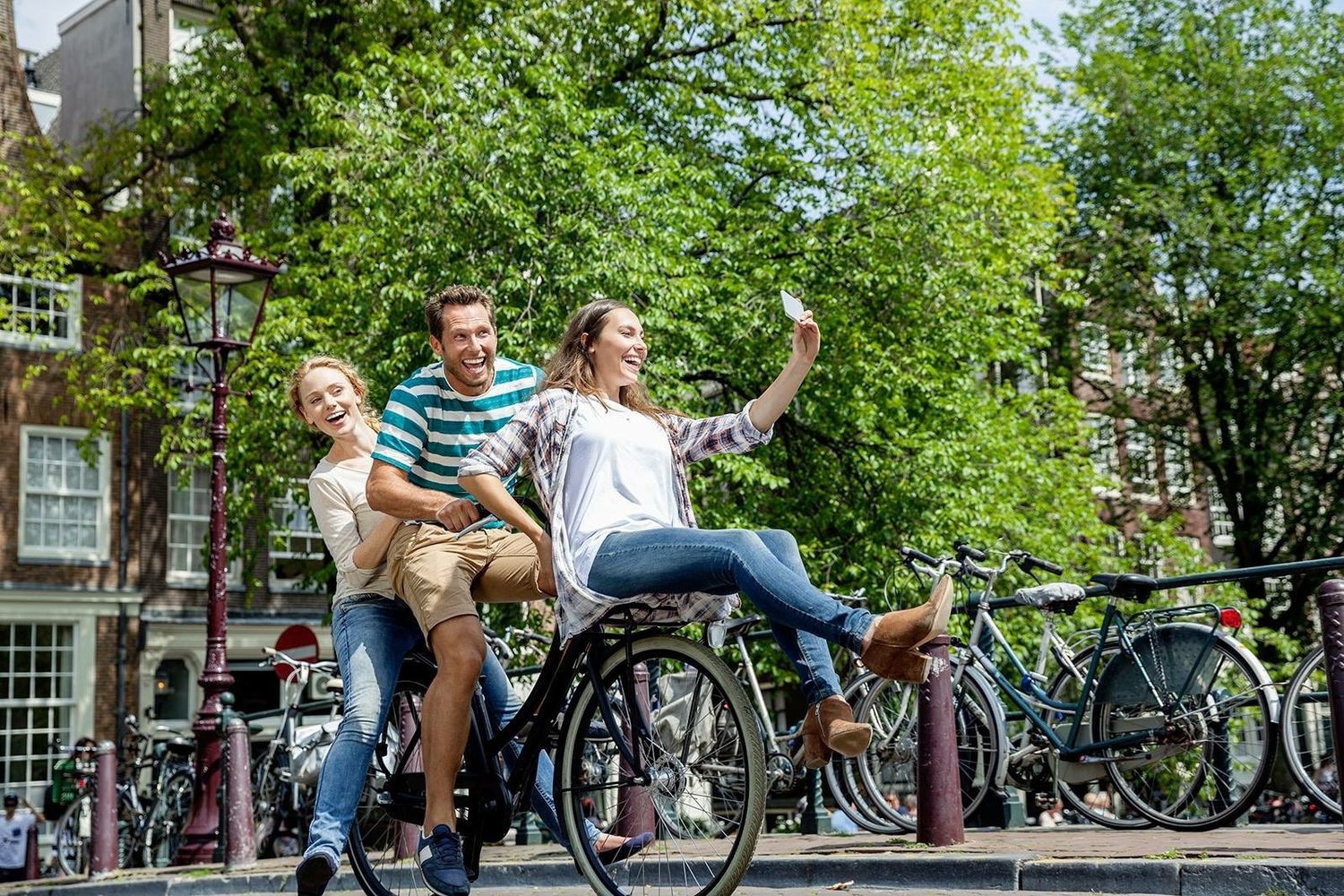 Urban lifestyle scene with three models cycling, relaxed interaction, natural light, commercial use