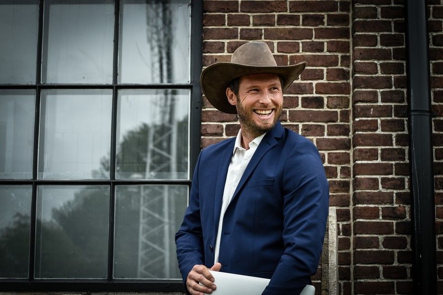 Peter Schotting in cowboy hat and blue blazer, commercial lifestyle portrait, smiling male model, outdoor photography