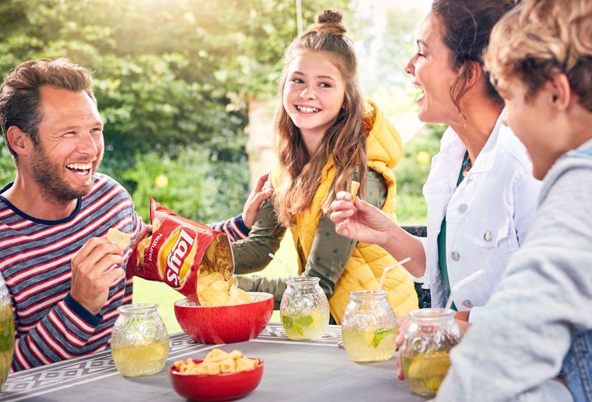 Family enjoying an outdoor meal together, lifestyle campaign photography, warm family moment