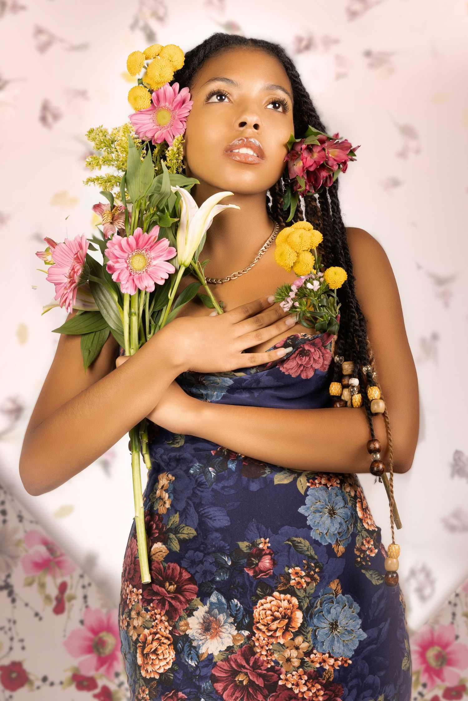 Artistic portrait featuring a floral dress and fresh flowers in pink and yellow against a soft background.