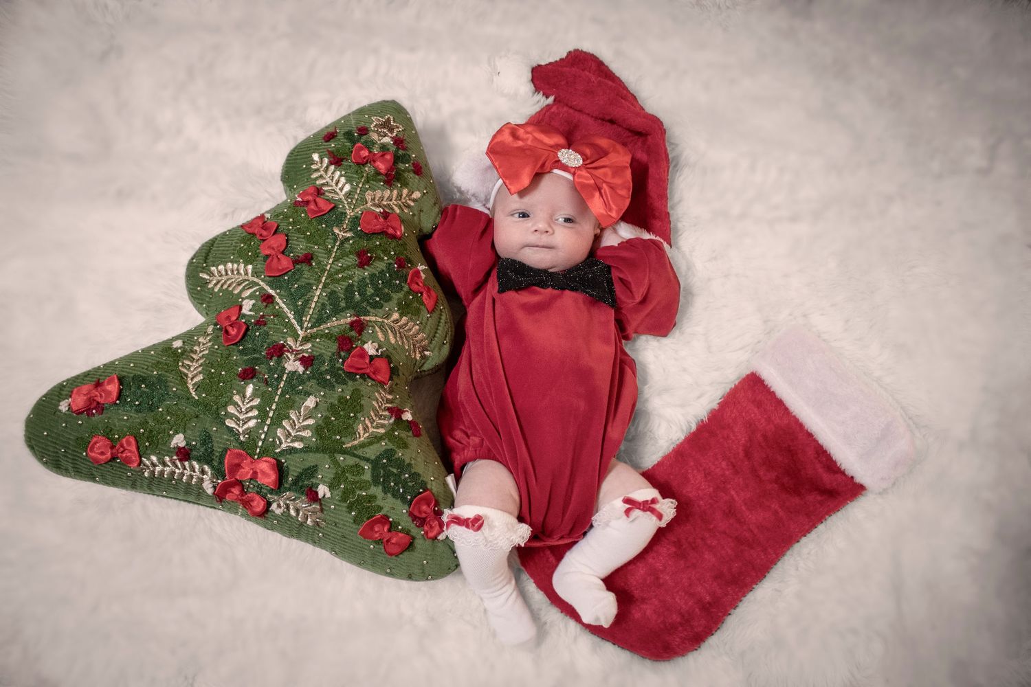 Overhead view of baby on festive red and green Christmas-themed blankets.
