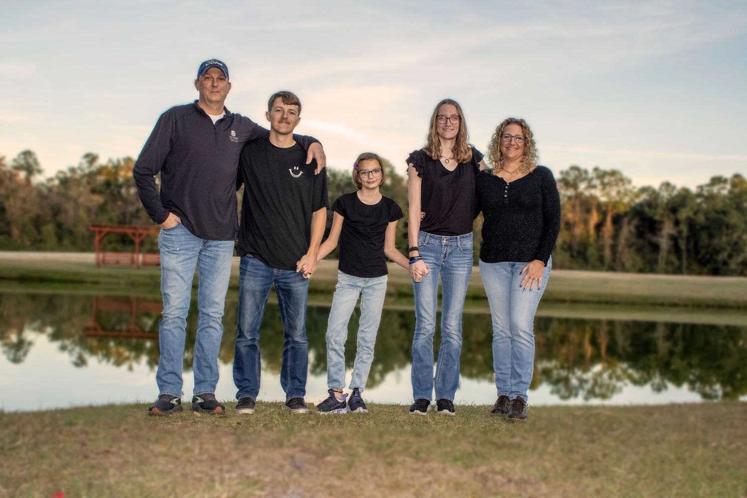 Family group photo session at sunset by a reflective lake.