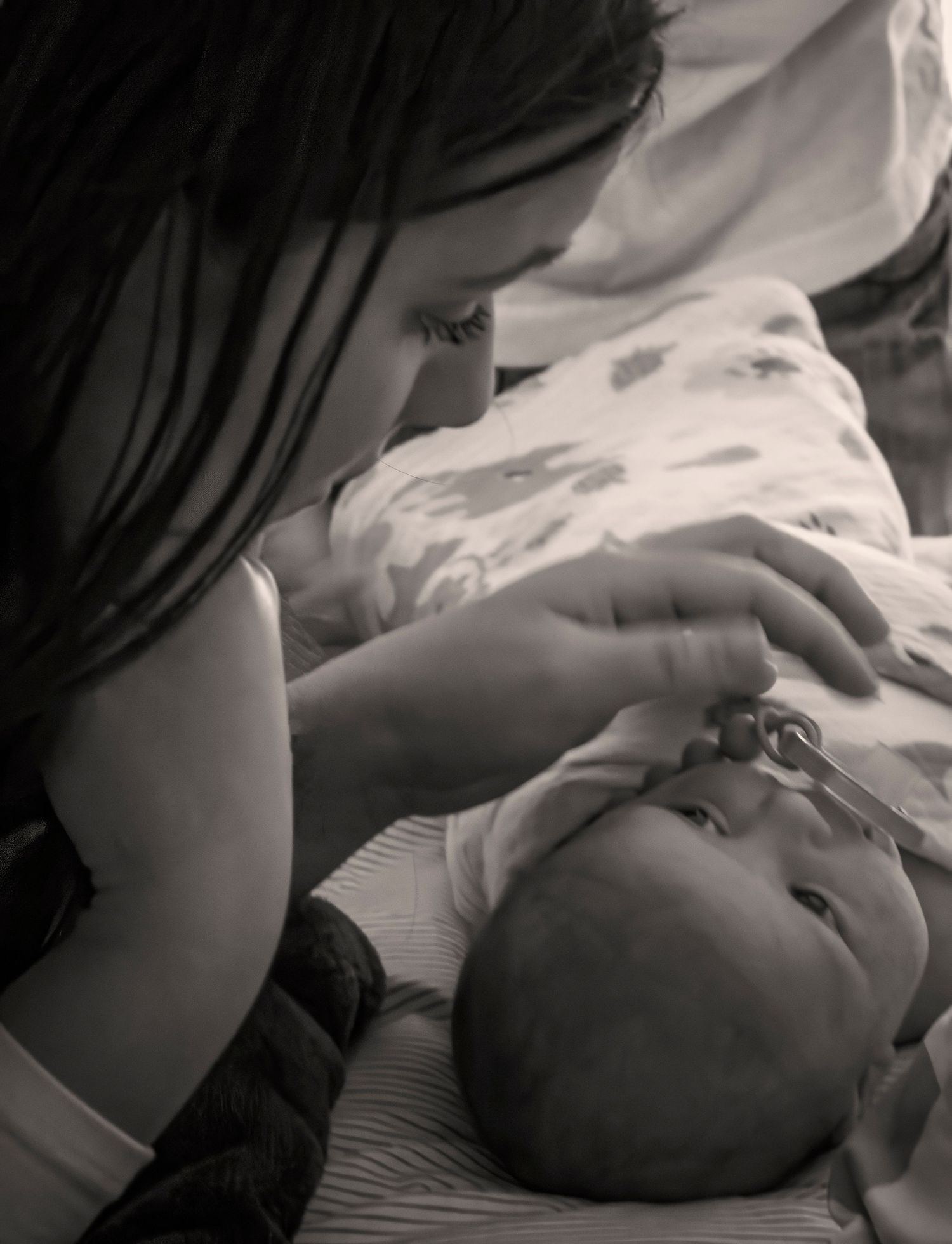 Intimate black and white moment between caregiver and infant.