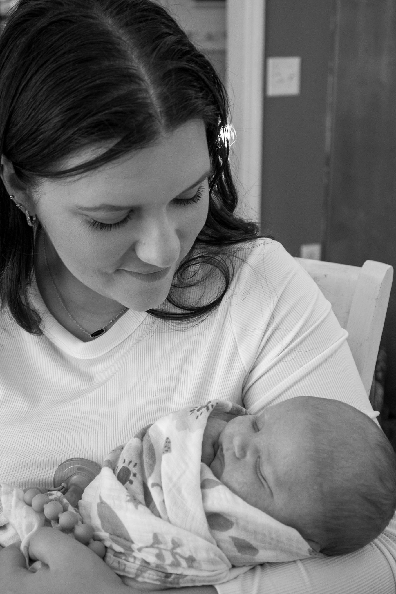 Intimate black and white sequence showing tender moments between parent and newborn.
