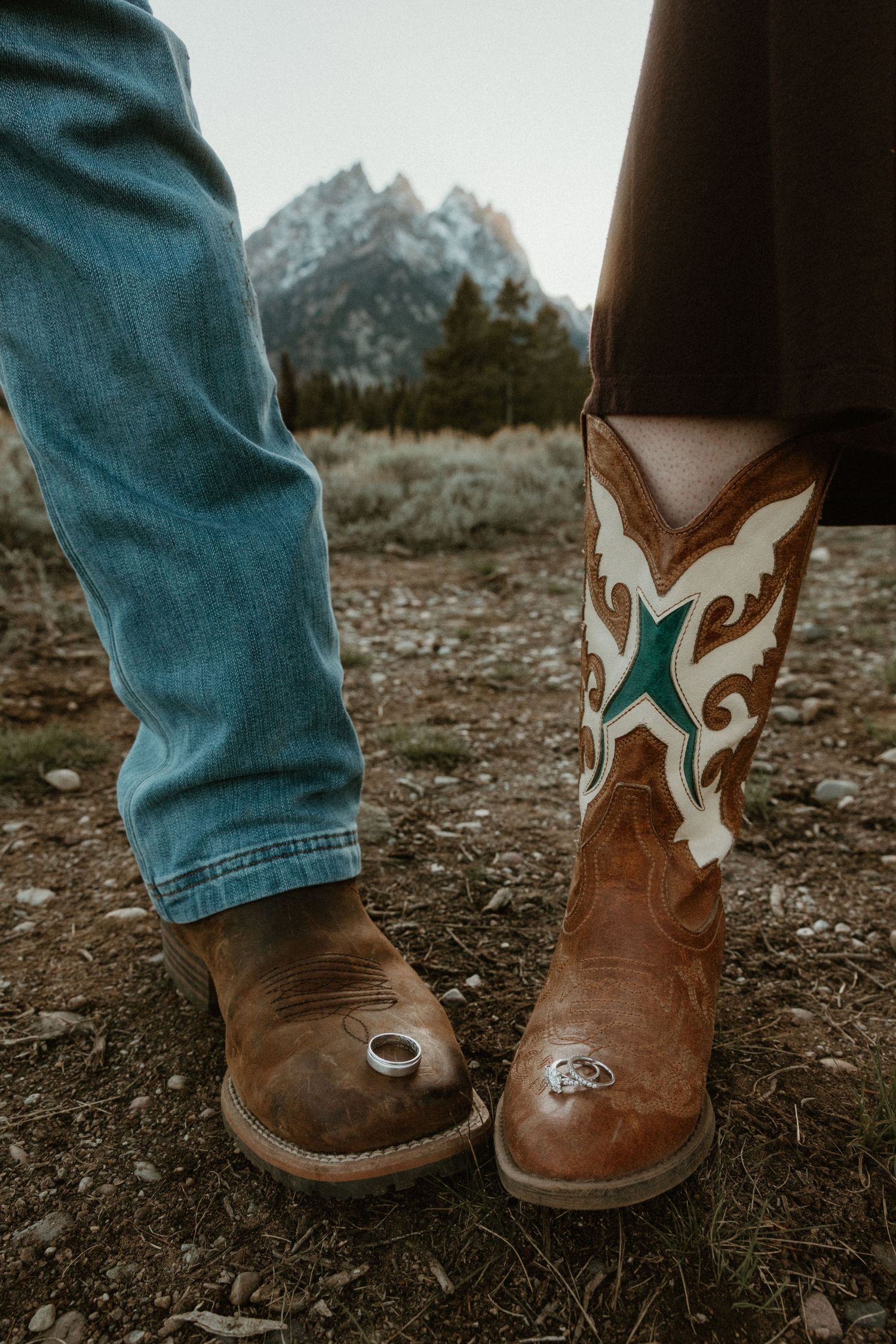 Two pairs of western boots standing together, one decorated with turquoise accents.