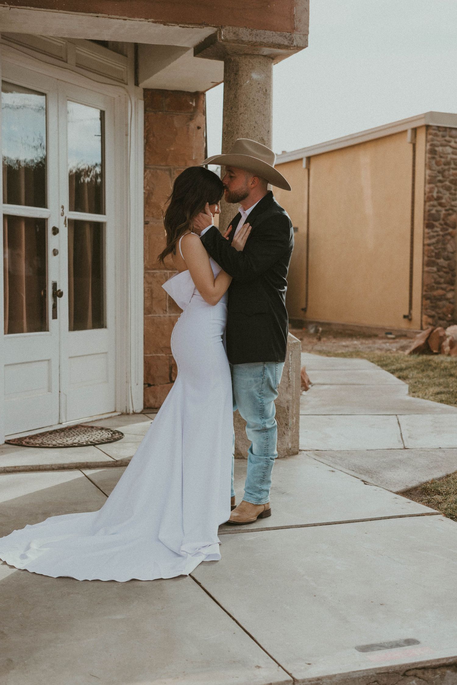 Romantic first look photos captured on outdoor concrete patio.