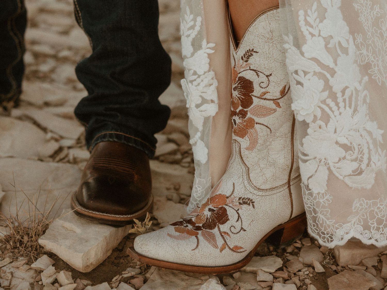 Close-up view of bride and groom's feet during a wedding ceremony against a lace dress background.