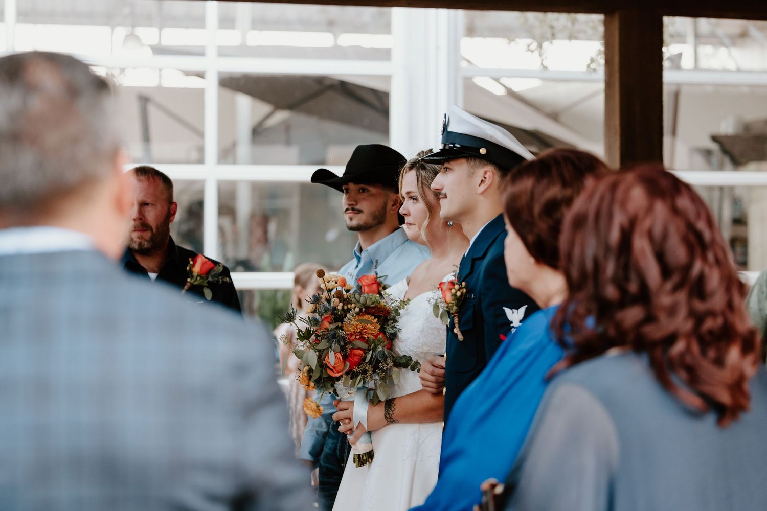 Wedding guests celebrate with joyful expressions during an outdoor ceremony.