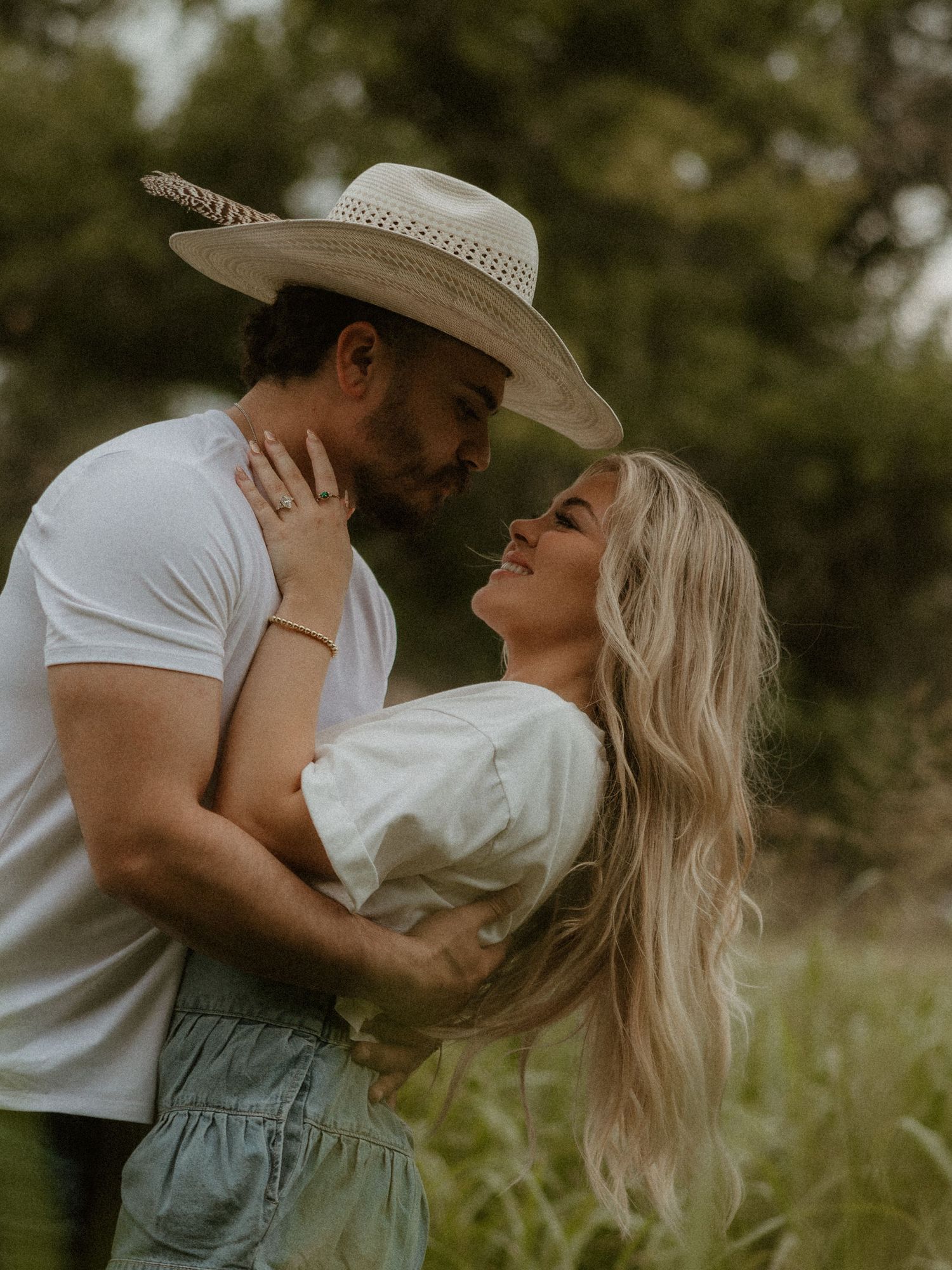 Intimate moments captured between couple during rustic outdoor photography session.