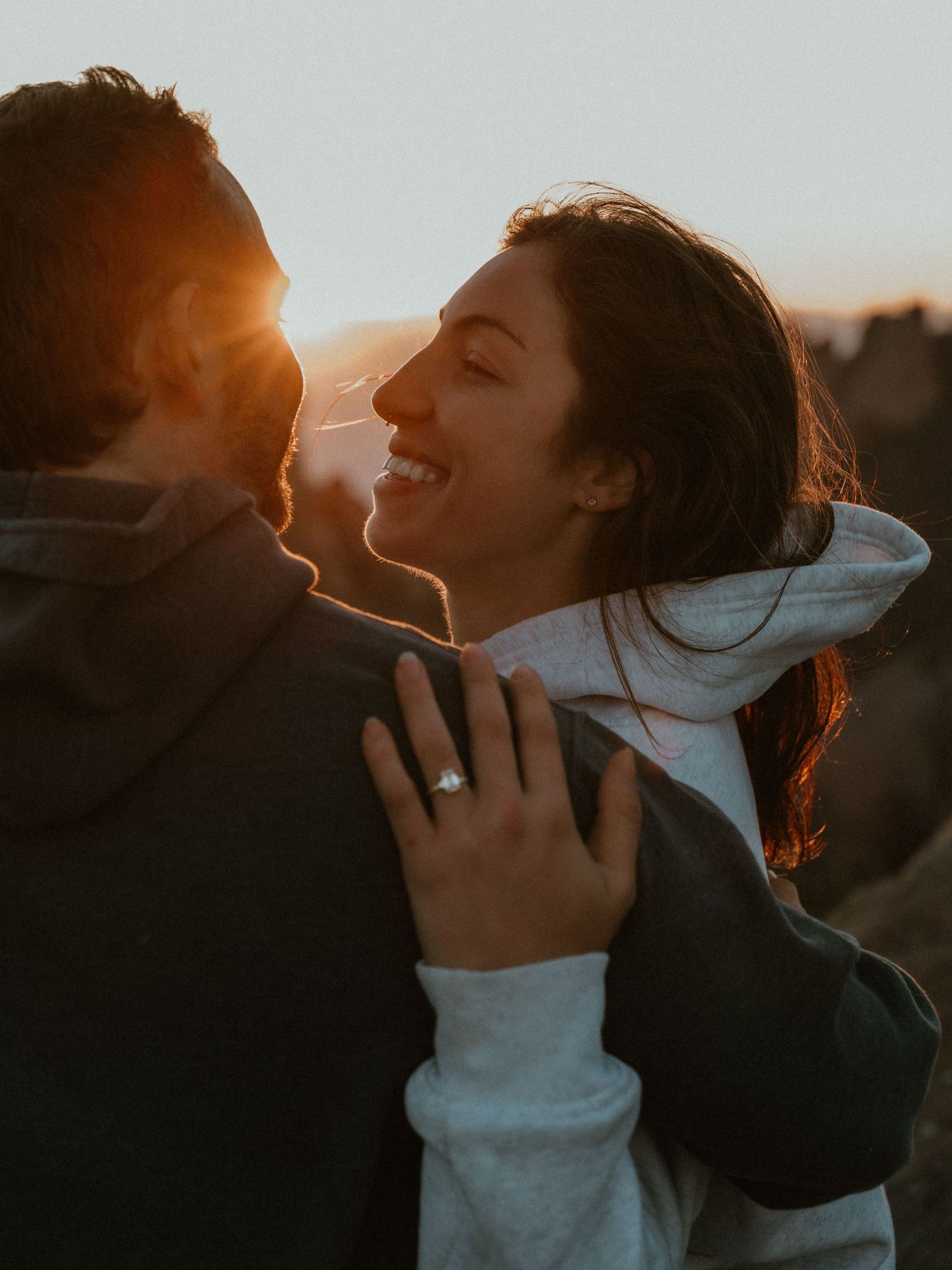 A joyful couple sharing an intimate moment during sunset in the mountains.