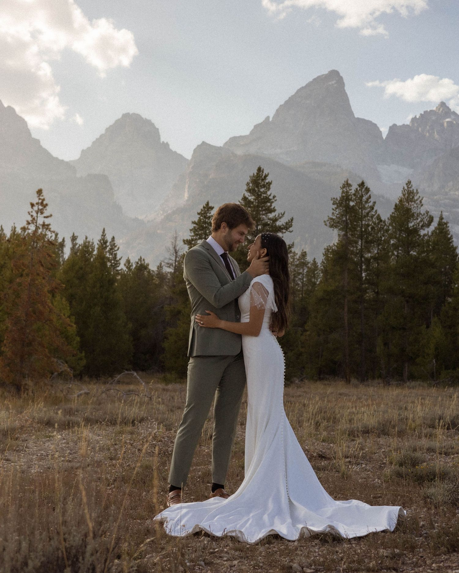 Romantic mountain wedding portraits with dramatic peaks and forest backdrop.