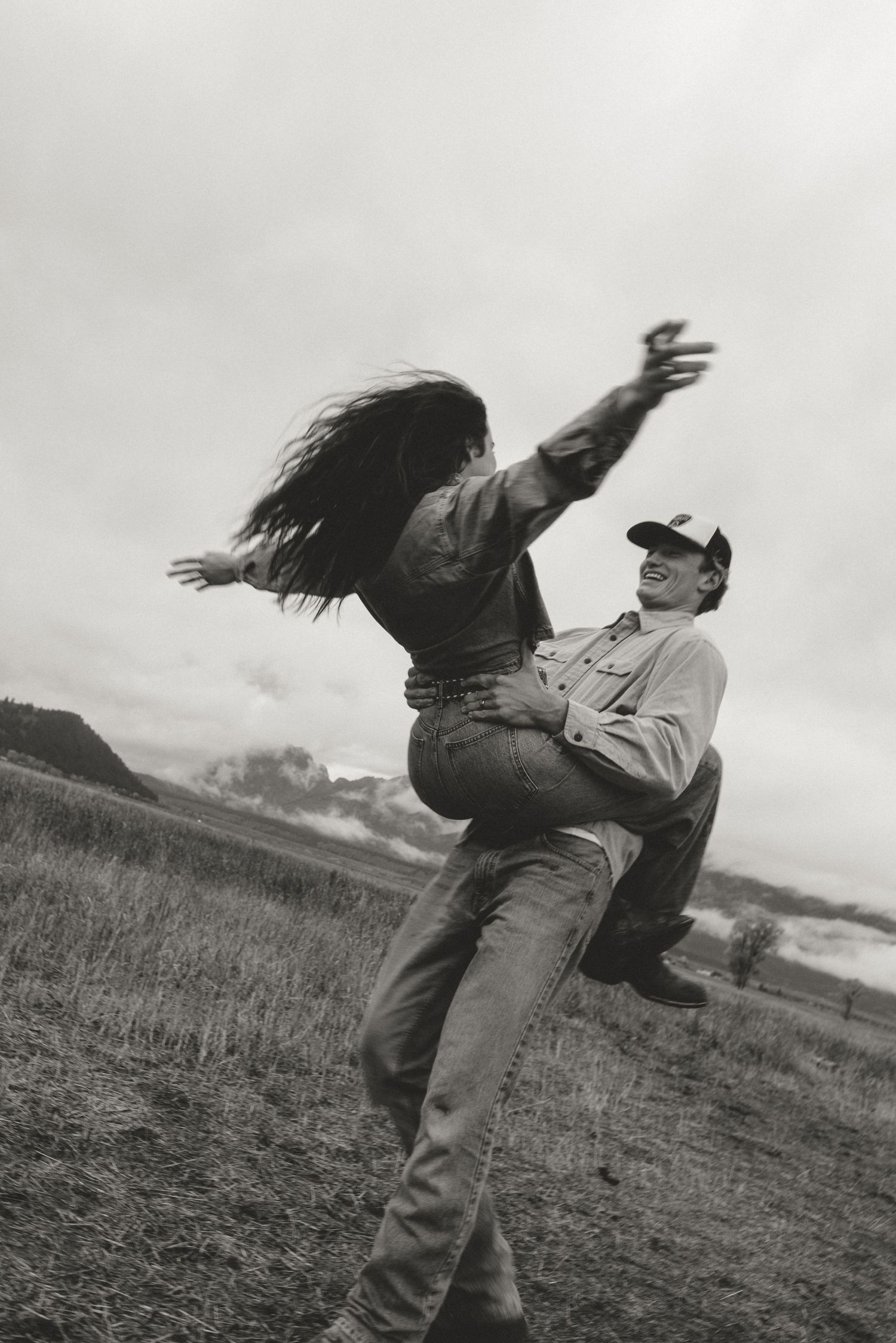 A dramatic black and white photo of two people dancing in a field.