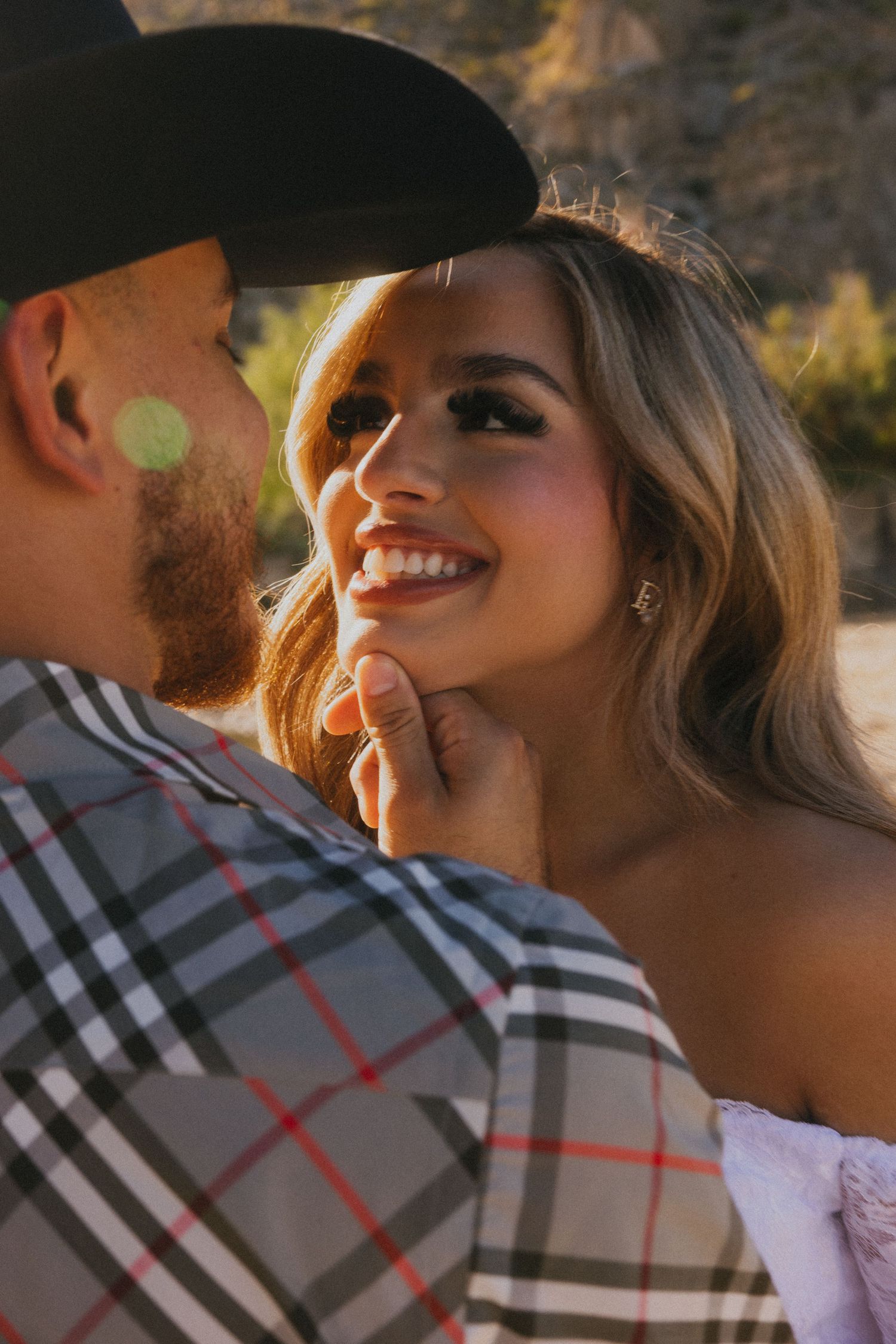 An intimate moment between a couple in western and formal attire against canyon backdrop.