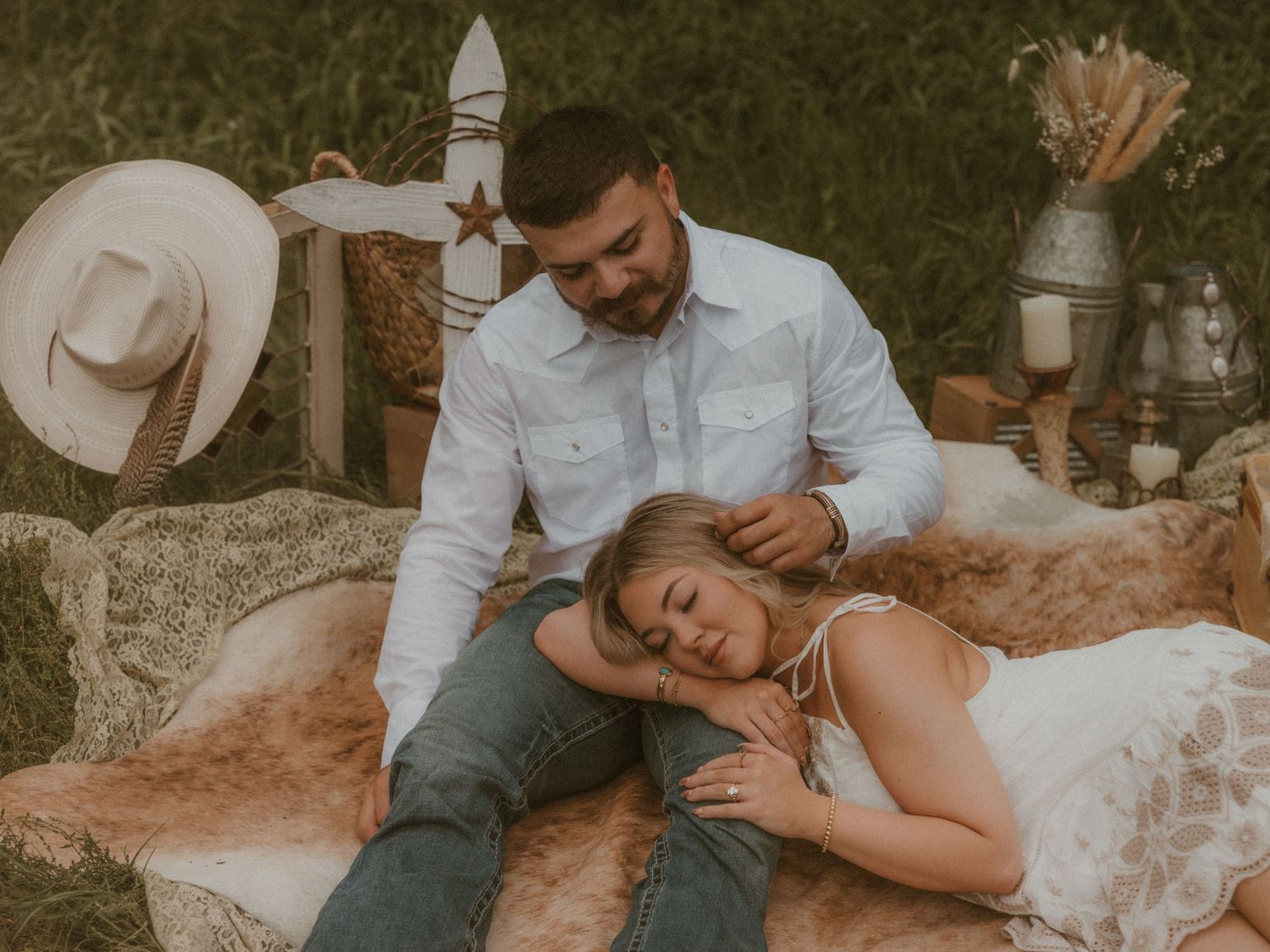 Romantic couple lying together on grass during an intimate outdoor photoshoot.