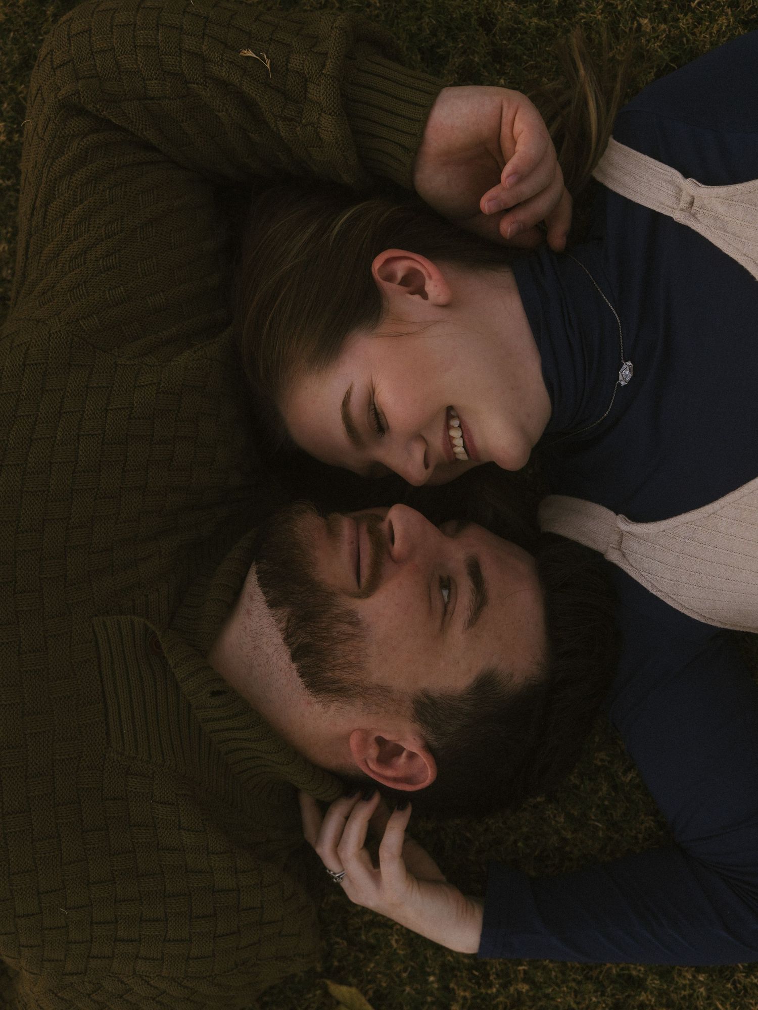 Intimate overhead shot of couple lying on textured surface.