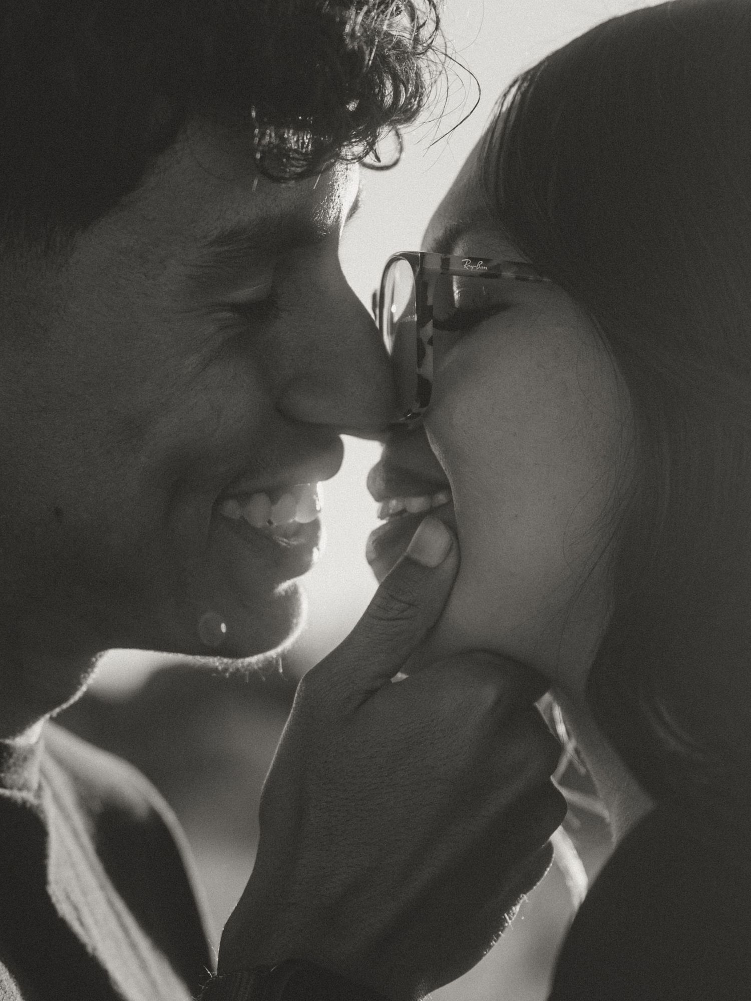 Romantic black and white portrait of couple in tender embrace with dramatic lighting.