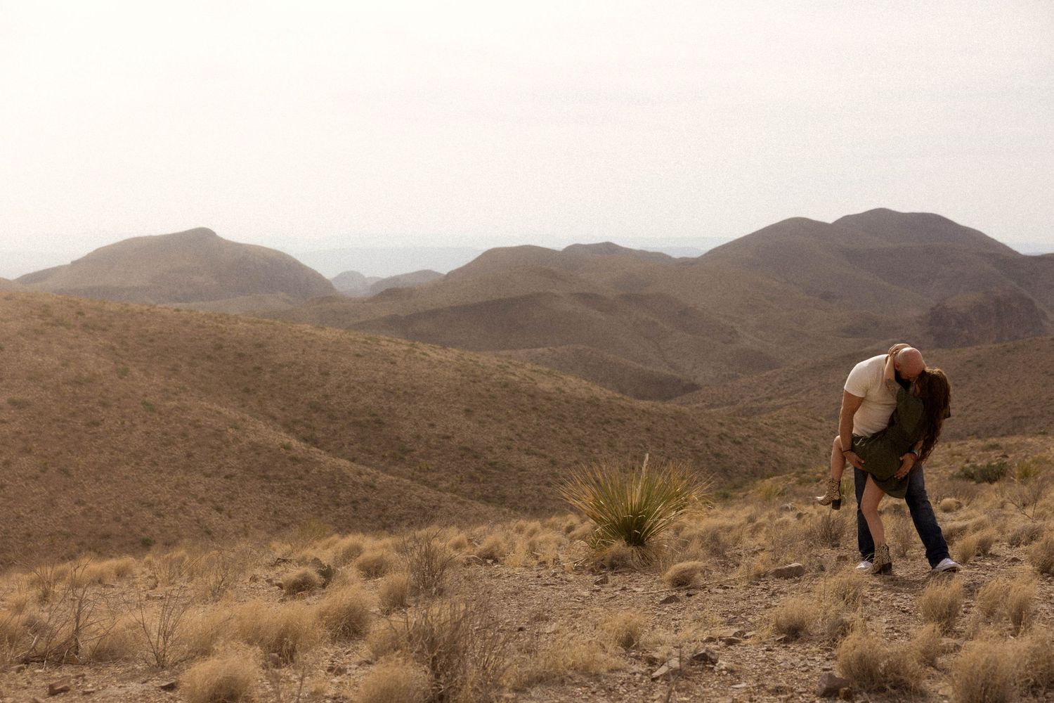 A rugged desert mountain landscape with brown rocky terrain stretches across the horizon.