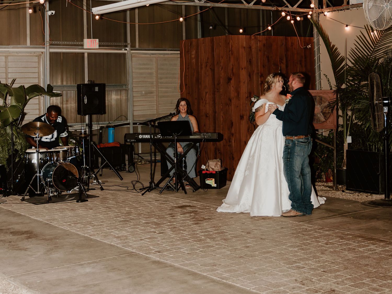 Wedding reception venue with rustic decor and ambient lighting.