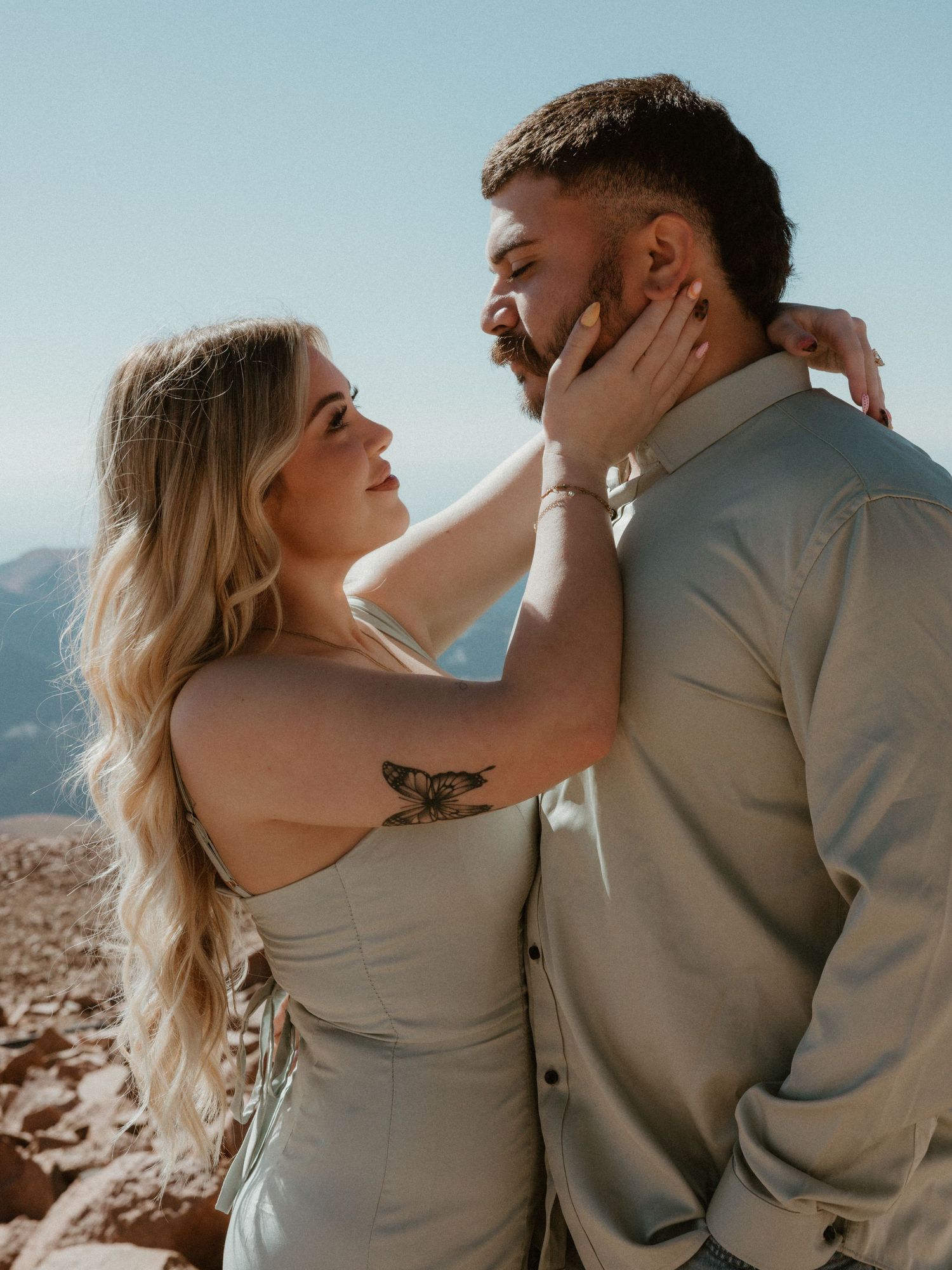 Sun-drenched romantic portrait session against desert mountain backdrop.