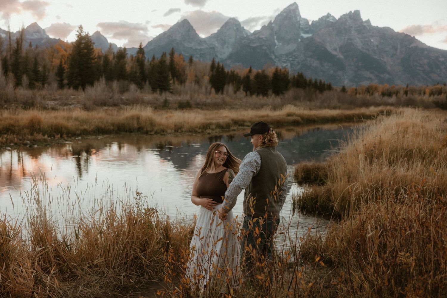 Scenic mountain vista with lake and autumn foliage framing a romantic moment.