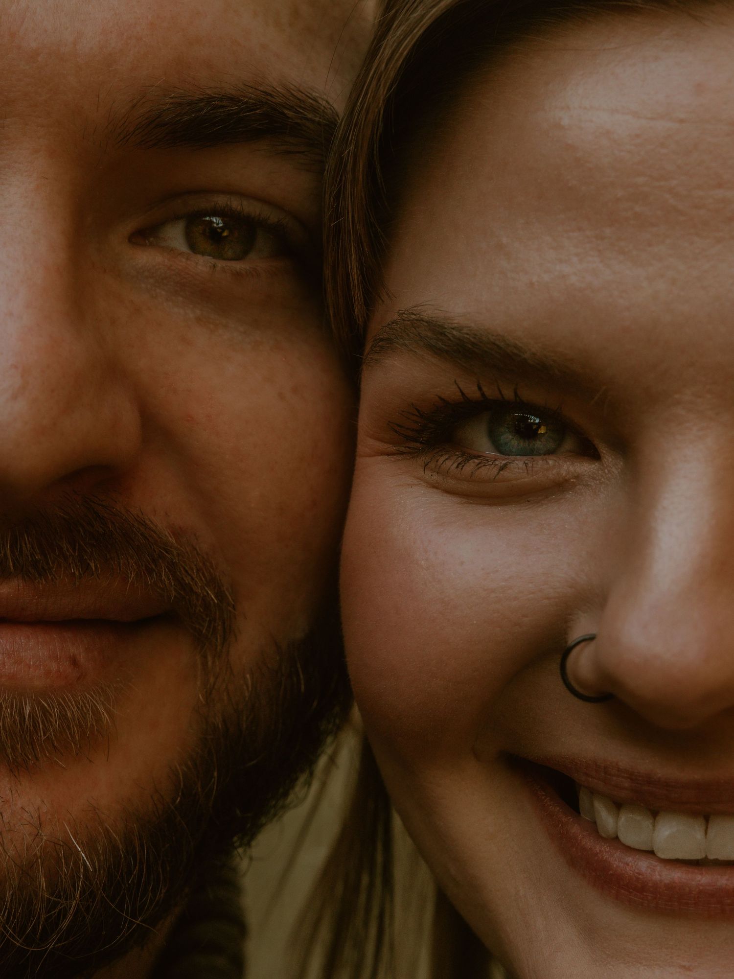 Close up shot of couple sharing an intimate moment with warm lighting.