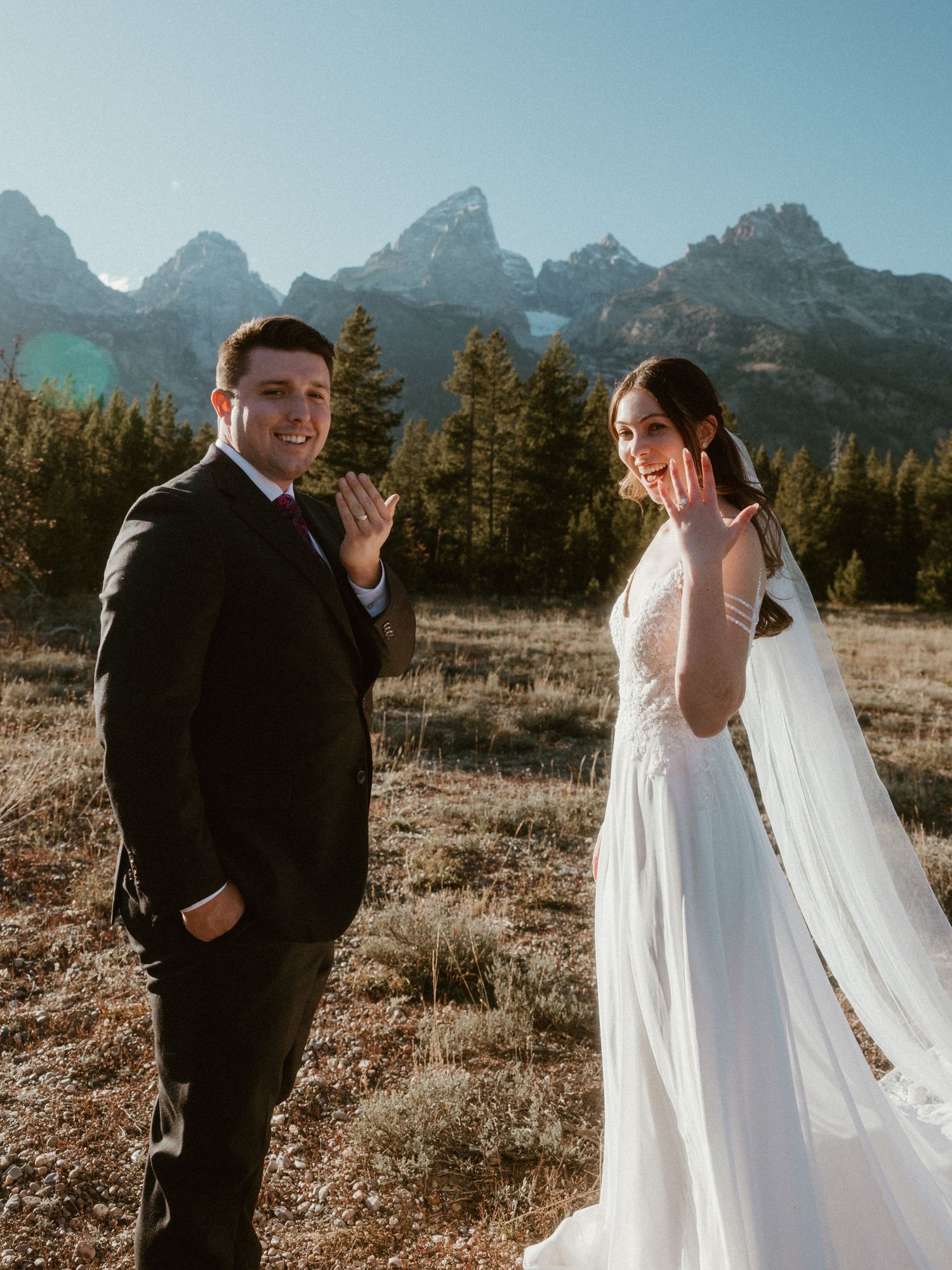 Wedding couple shares emotional first look moment with mountain landscape in background.