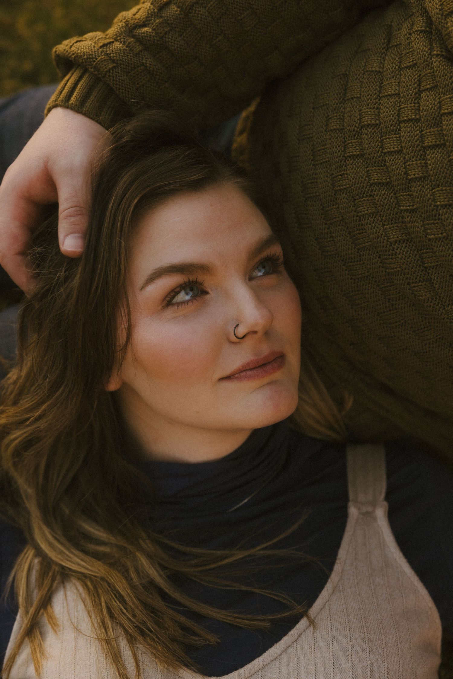 Close up portrait in warm lighting showing gentle intimate moment.