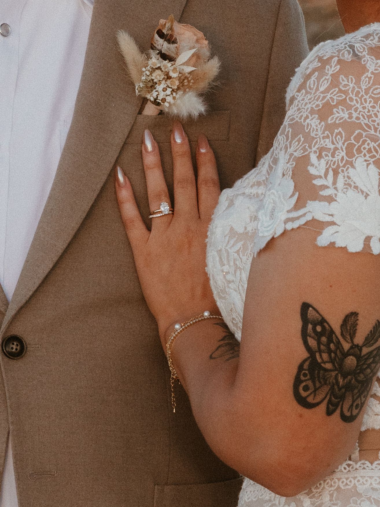 Close-up of wedding rings and lace details against formal attire.