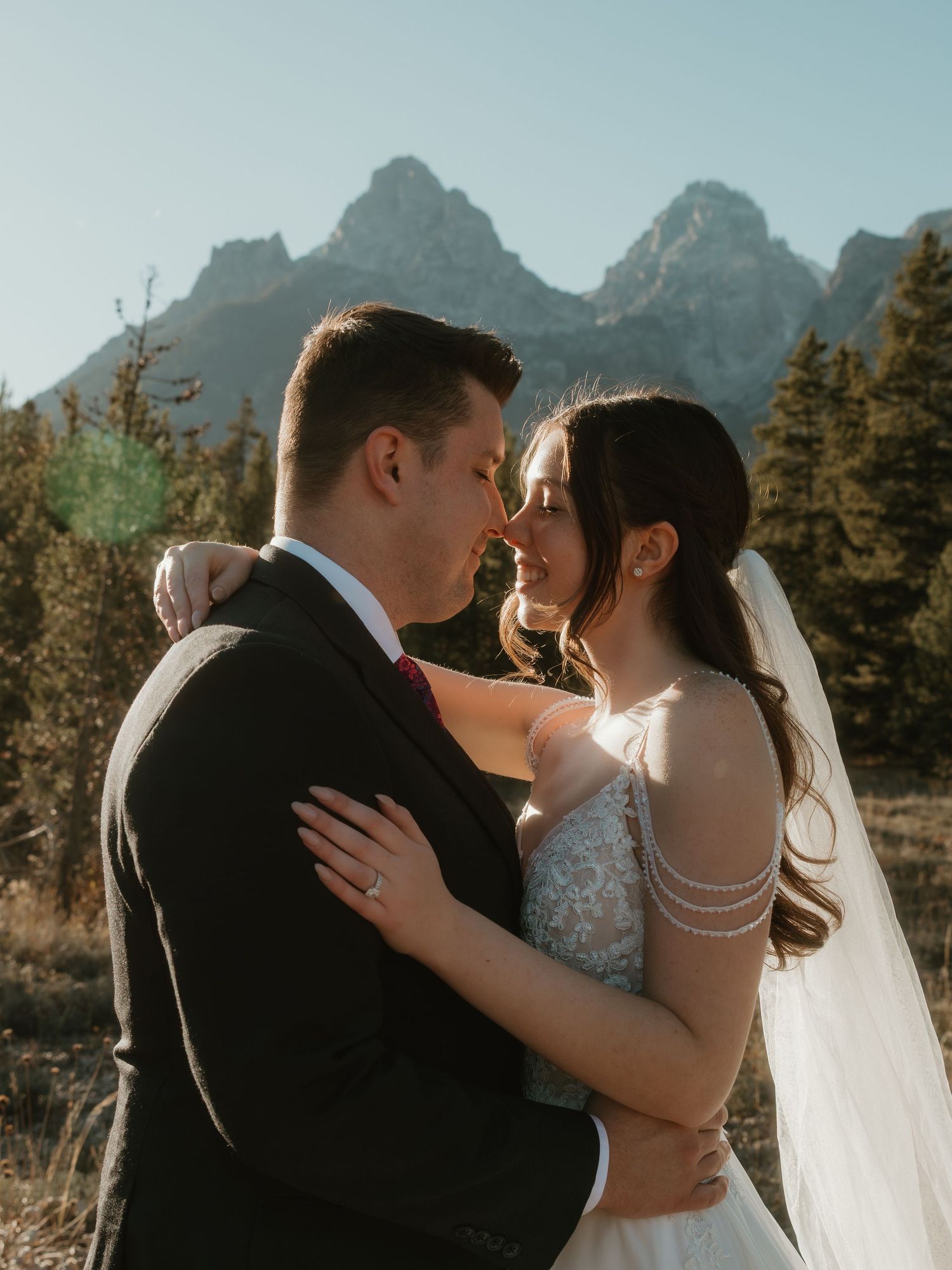 Romantic wedding portraits captured against dramatic mountain scenery and evergreen forest.